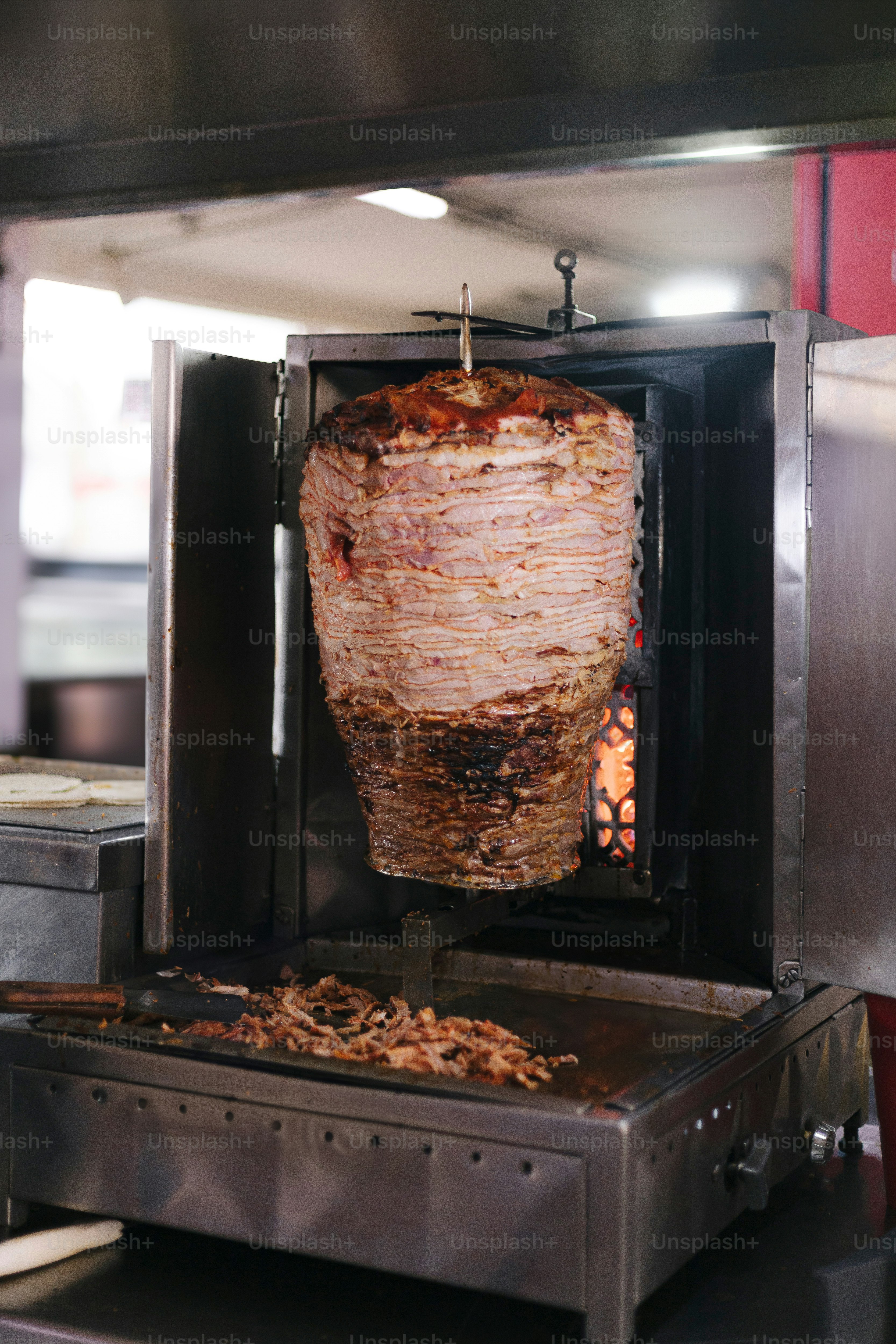 A large piece of meat is being cooked on a grill