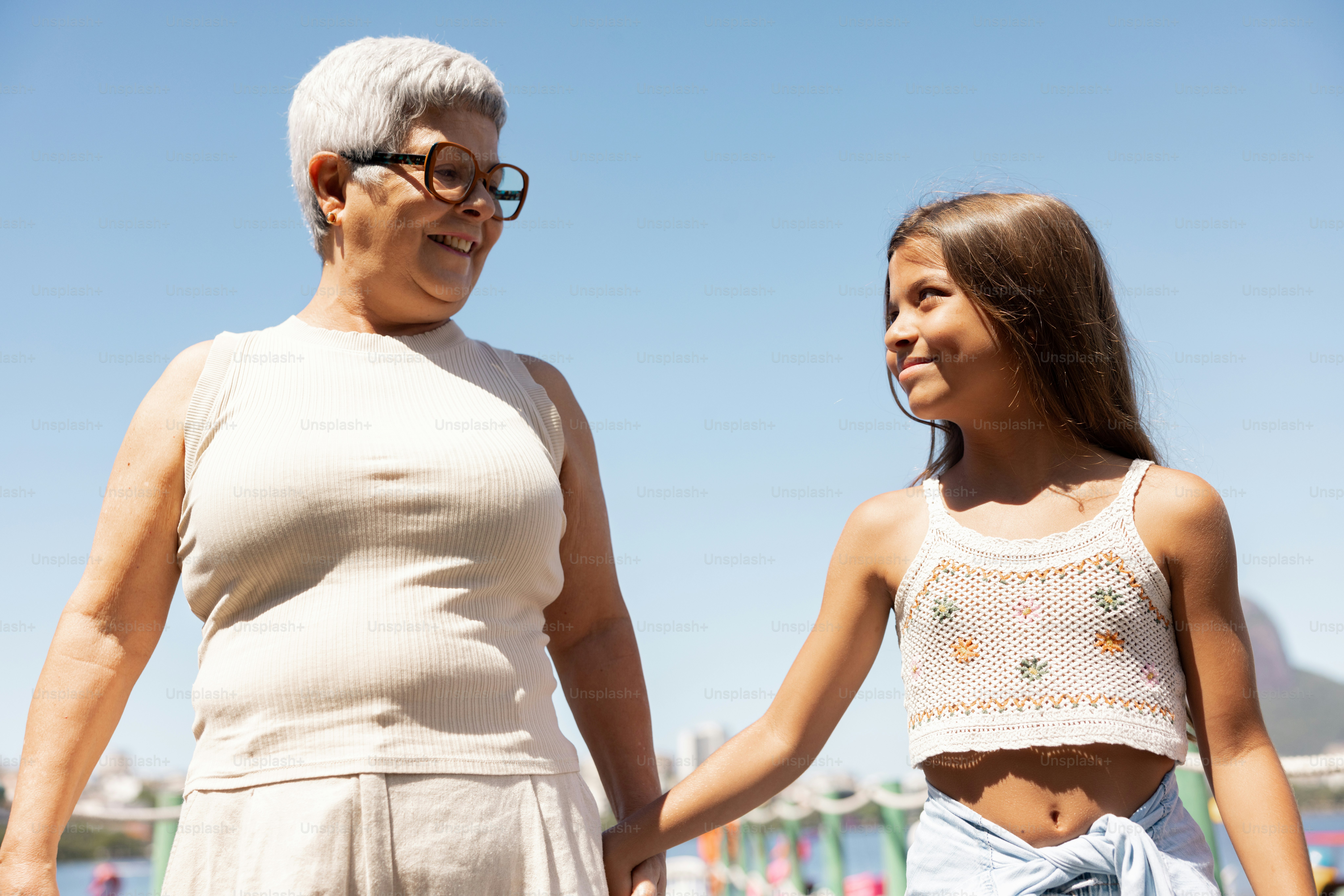 An older woman and a young girl holding hands photo – Woman Image on ...