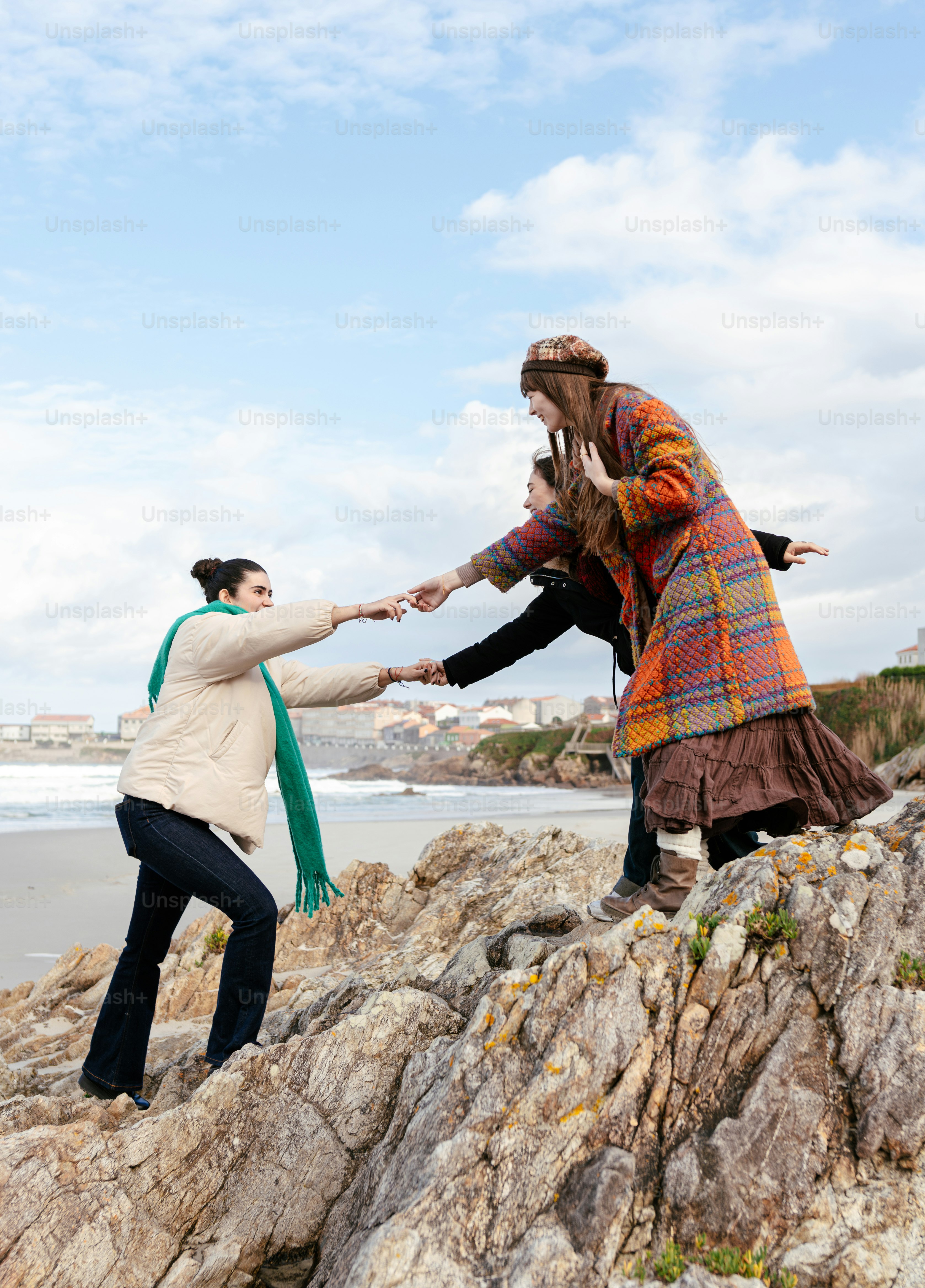 Two people are standing on rocks near the water