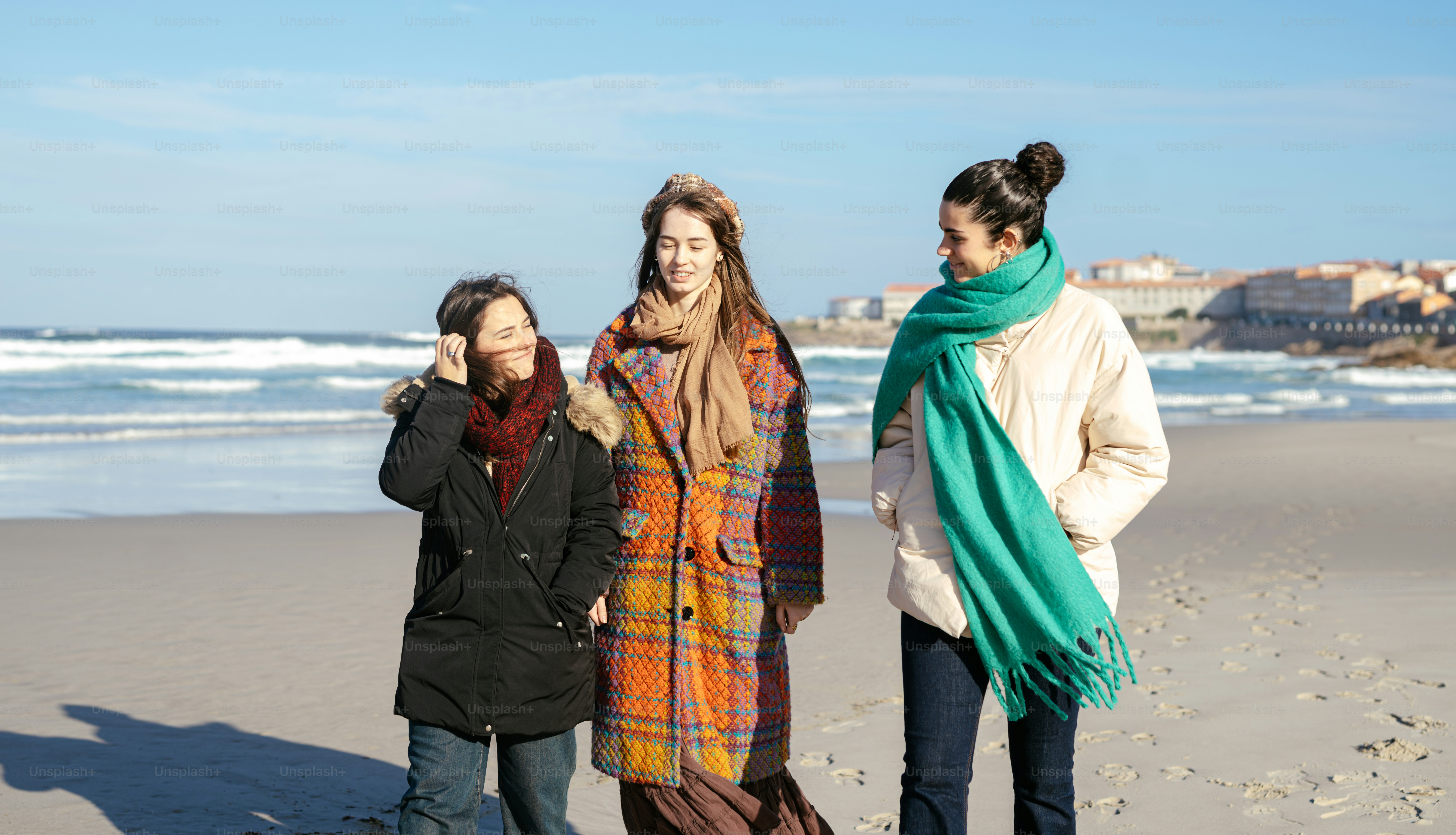 A group of women standing on top of a sandy beach