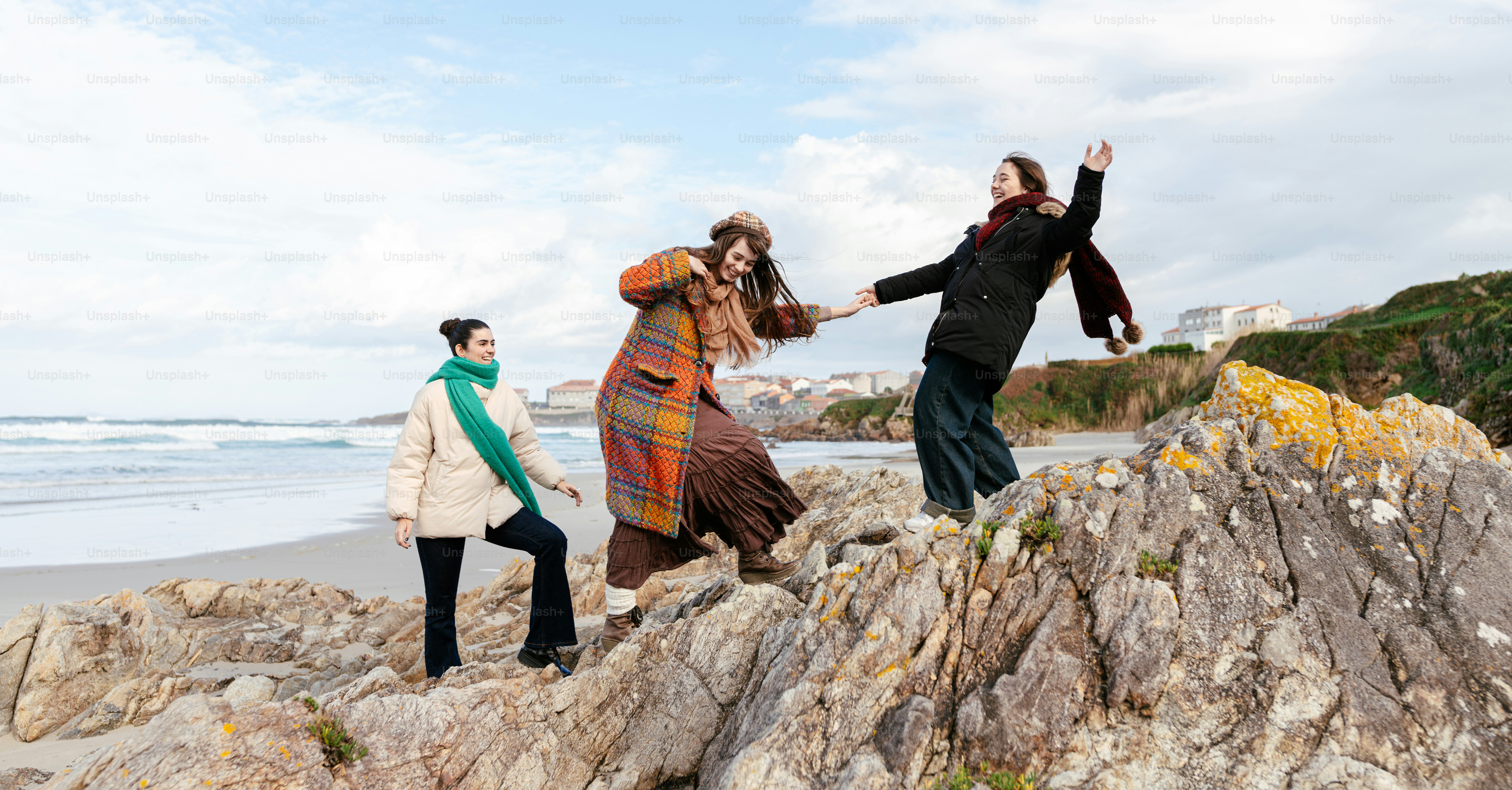 A group of people standing on top of a rocky beach
