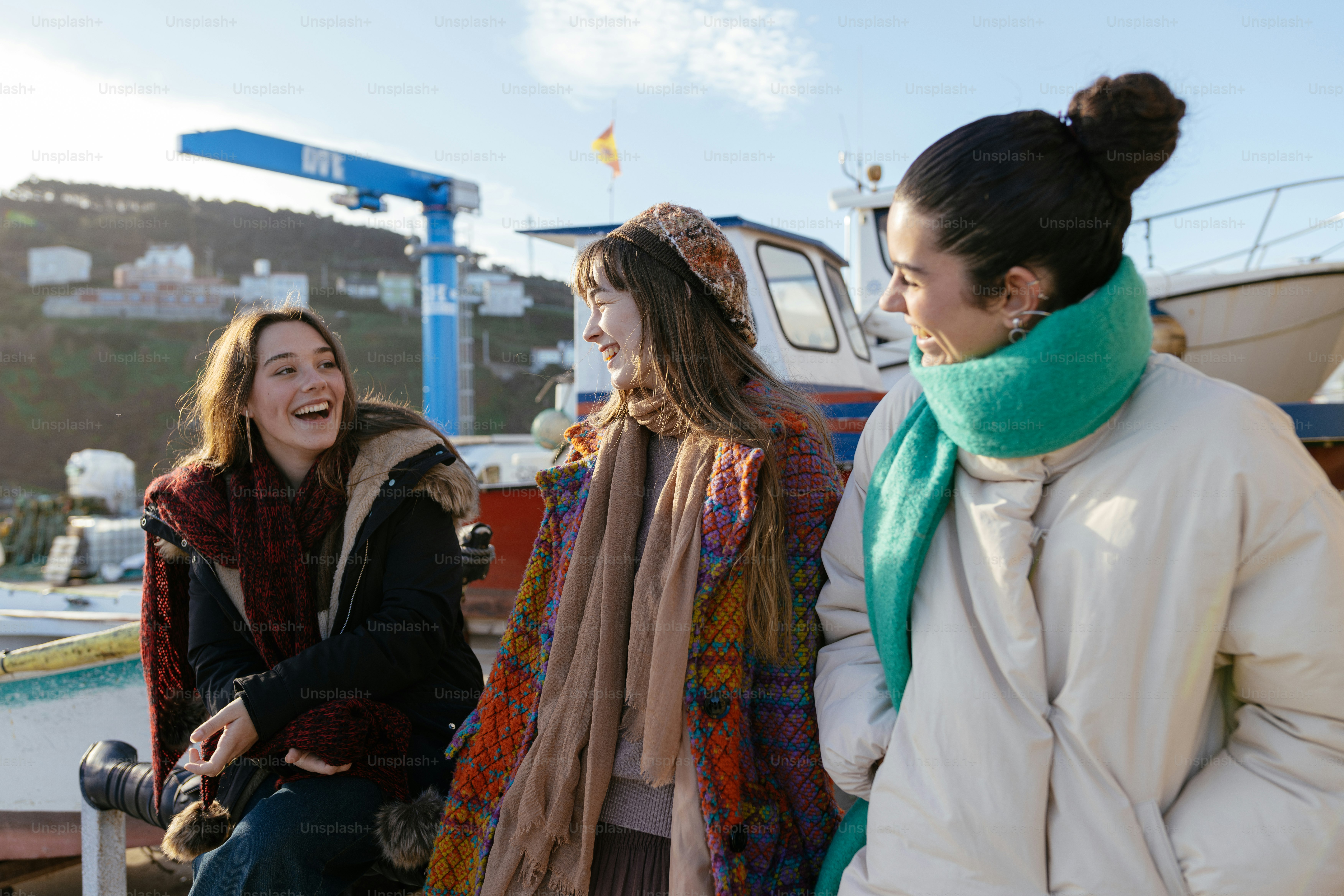 A group of women standing next to each other near a boat