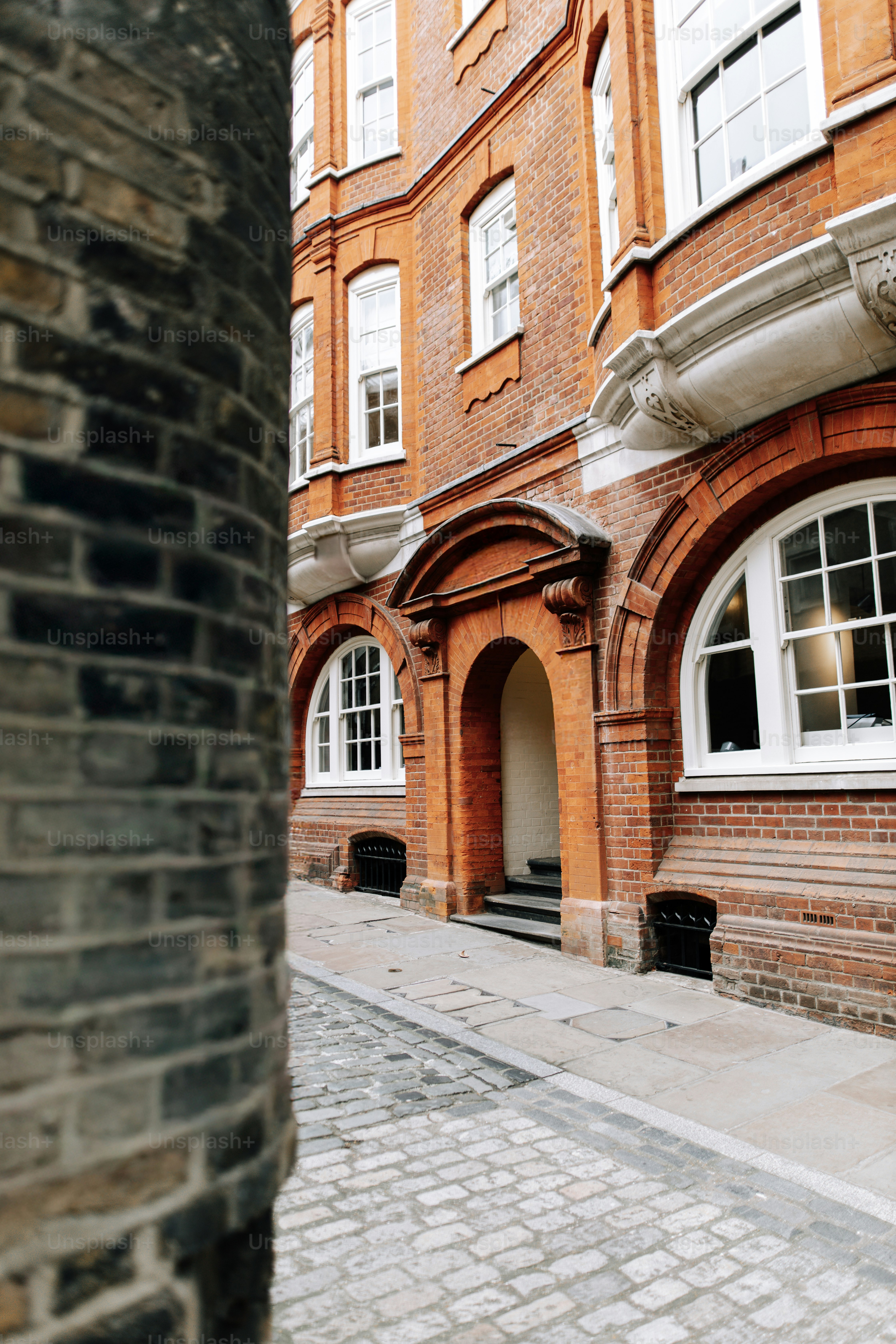 A brick building with white windows on a street