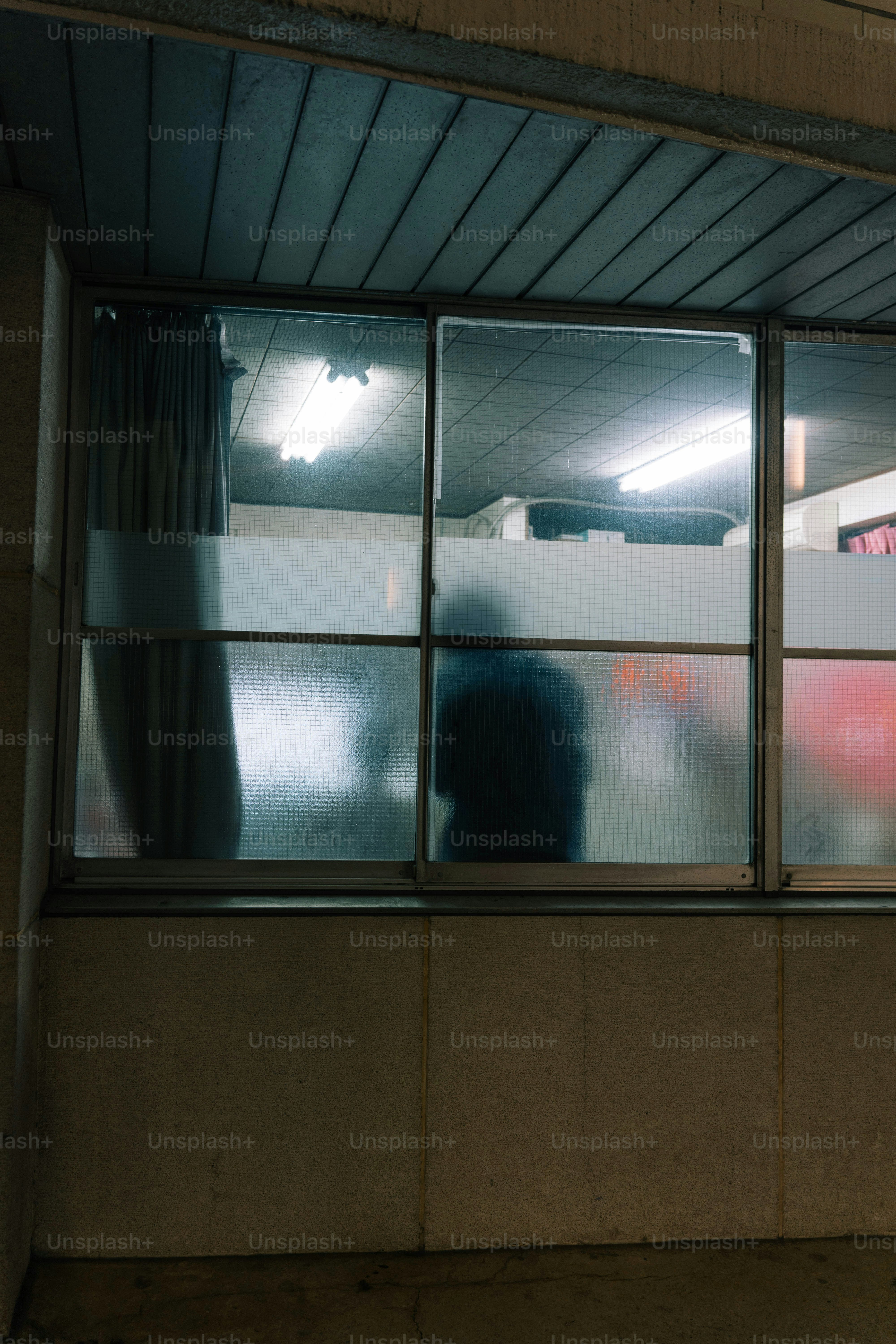 A person standing in front of a window in a building