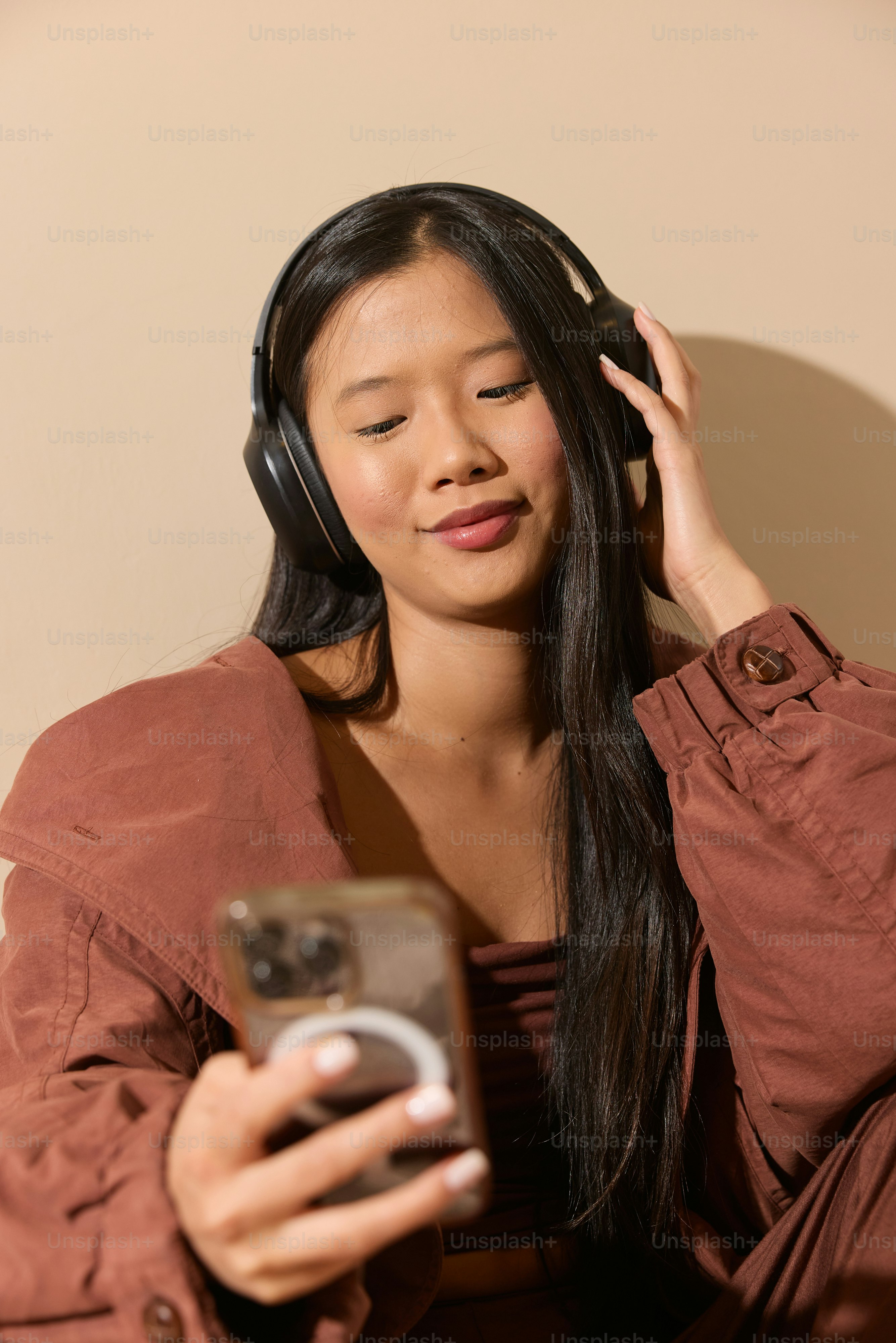 A woman sitting on a couch looking at her cell phone