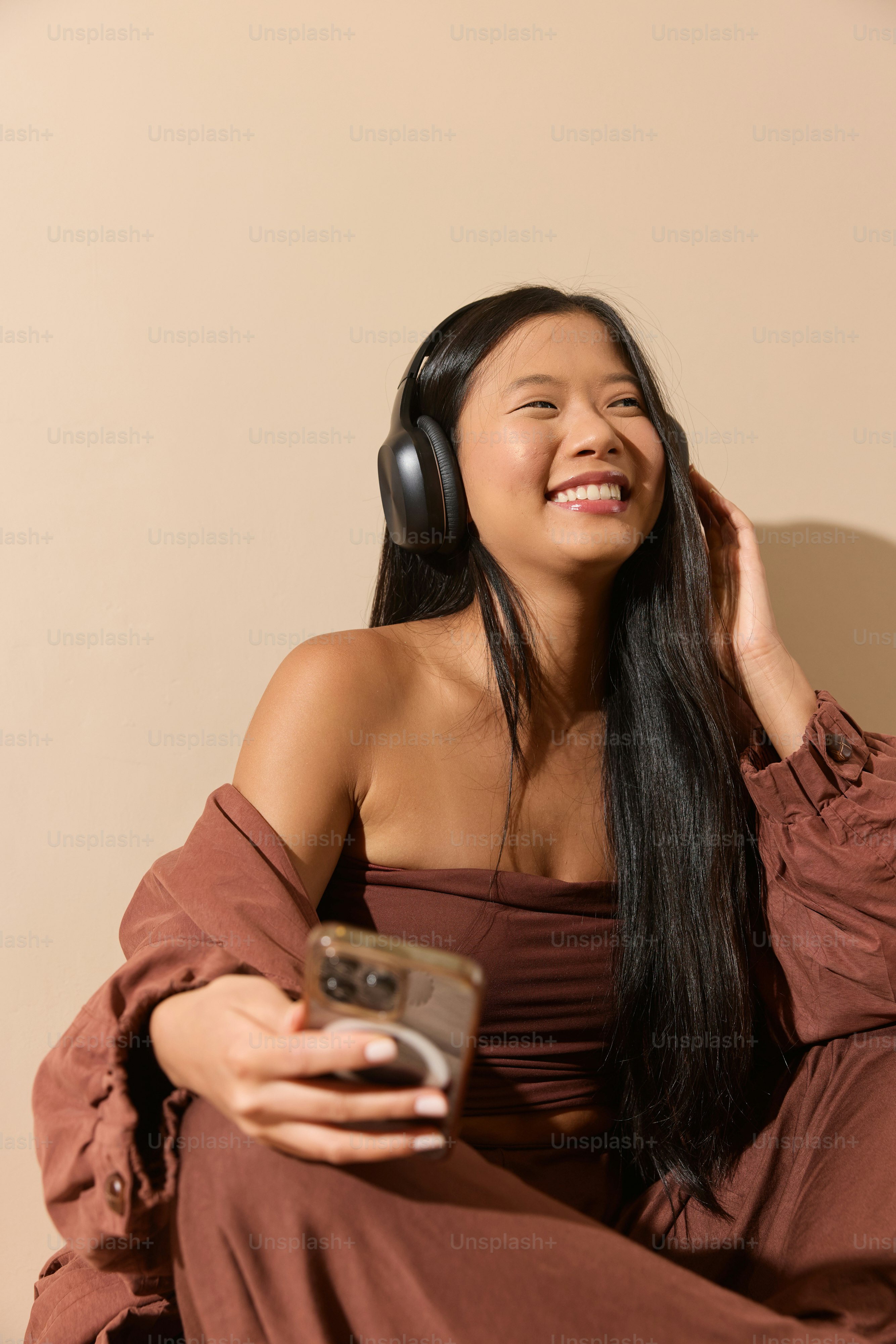 A woman in a brown dress listening to music