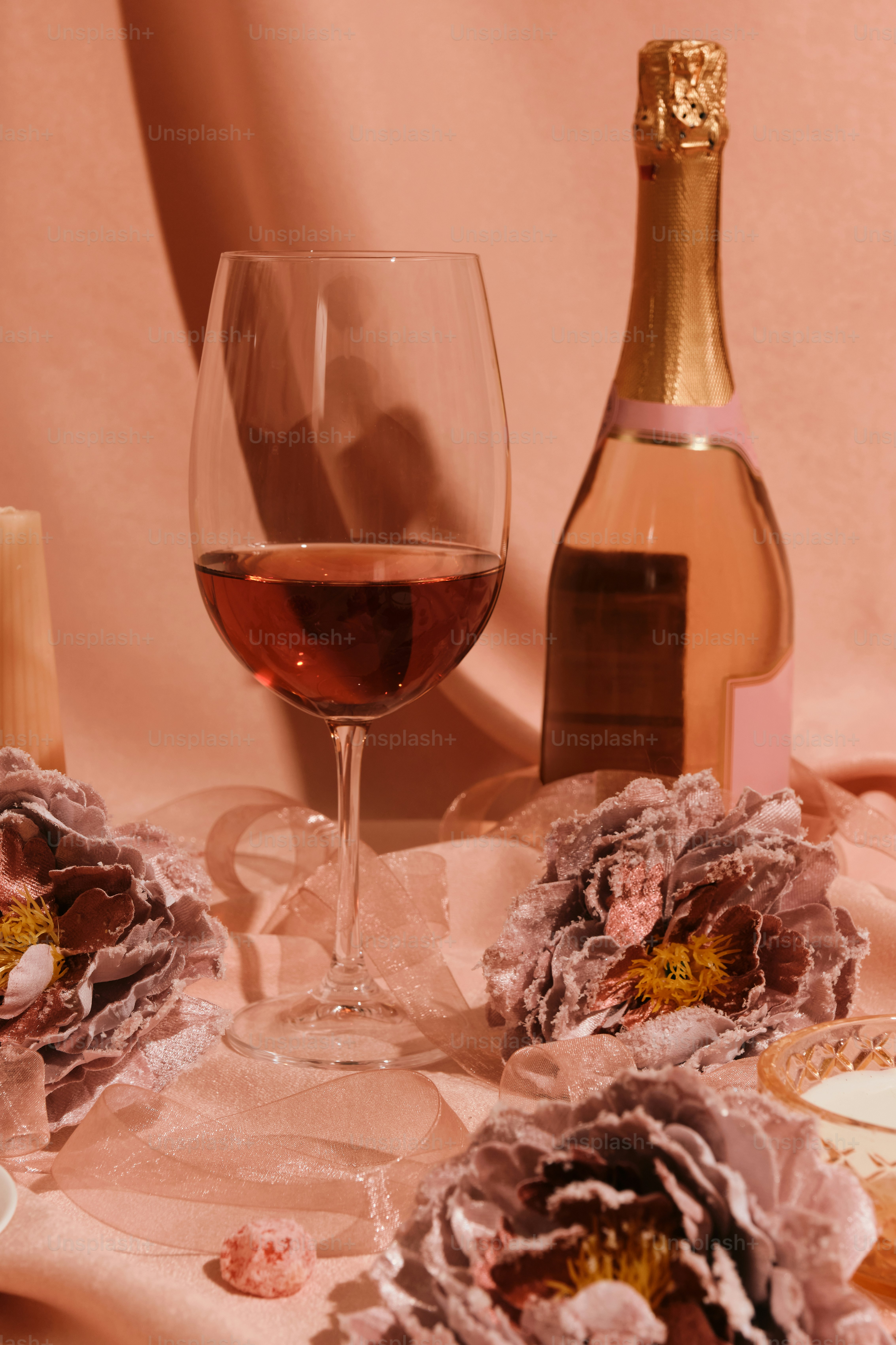 Una mesa cubierta con una copa de vino junto a una botella de vino