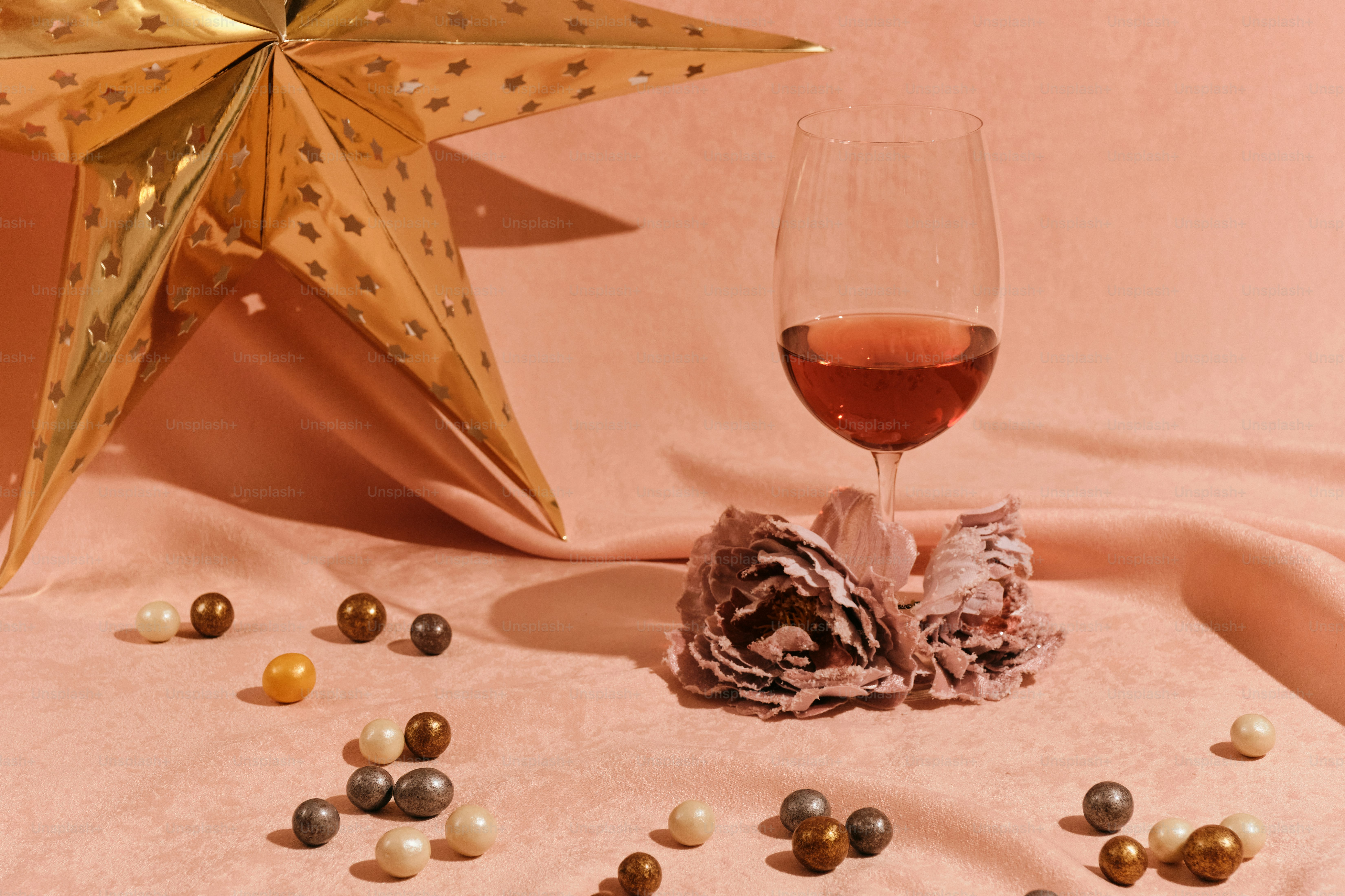 Una copa de vino sentada junto a una estrella dorada