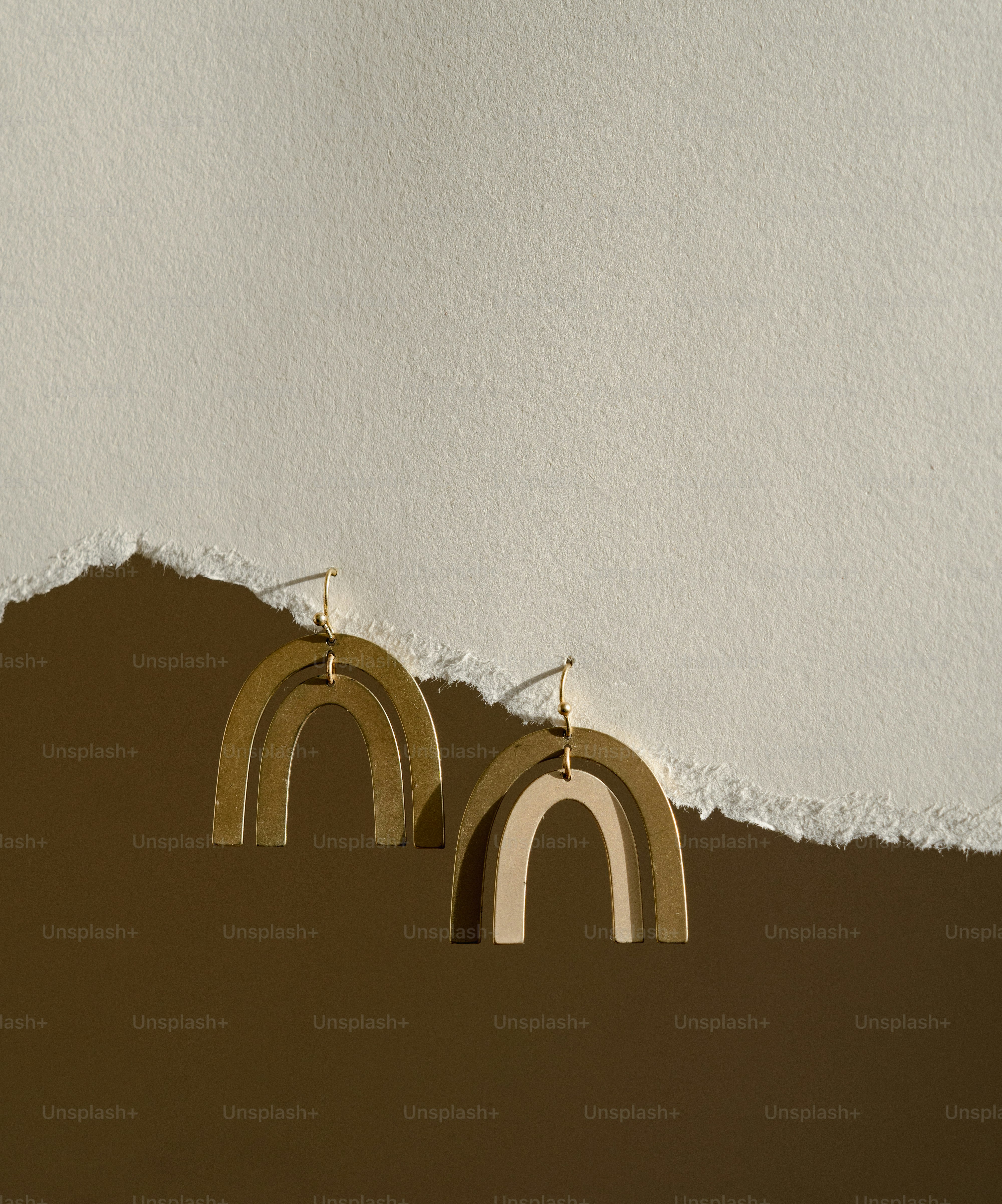 A pair of earrings hanging from a hole in a wall