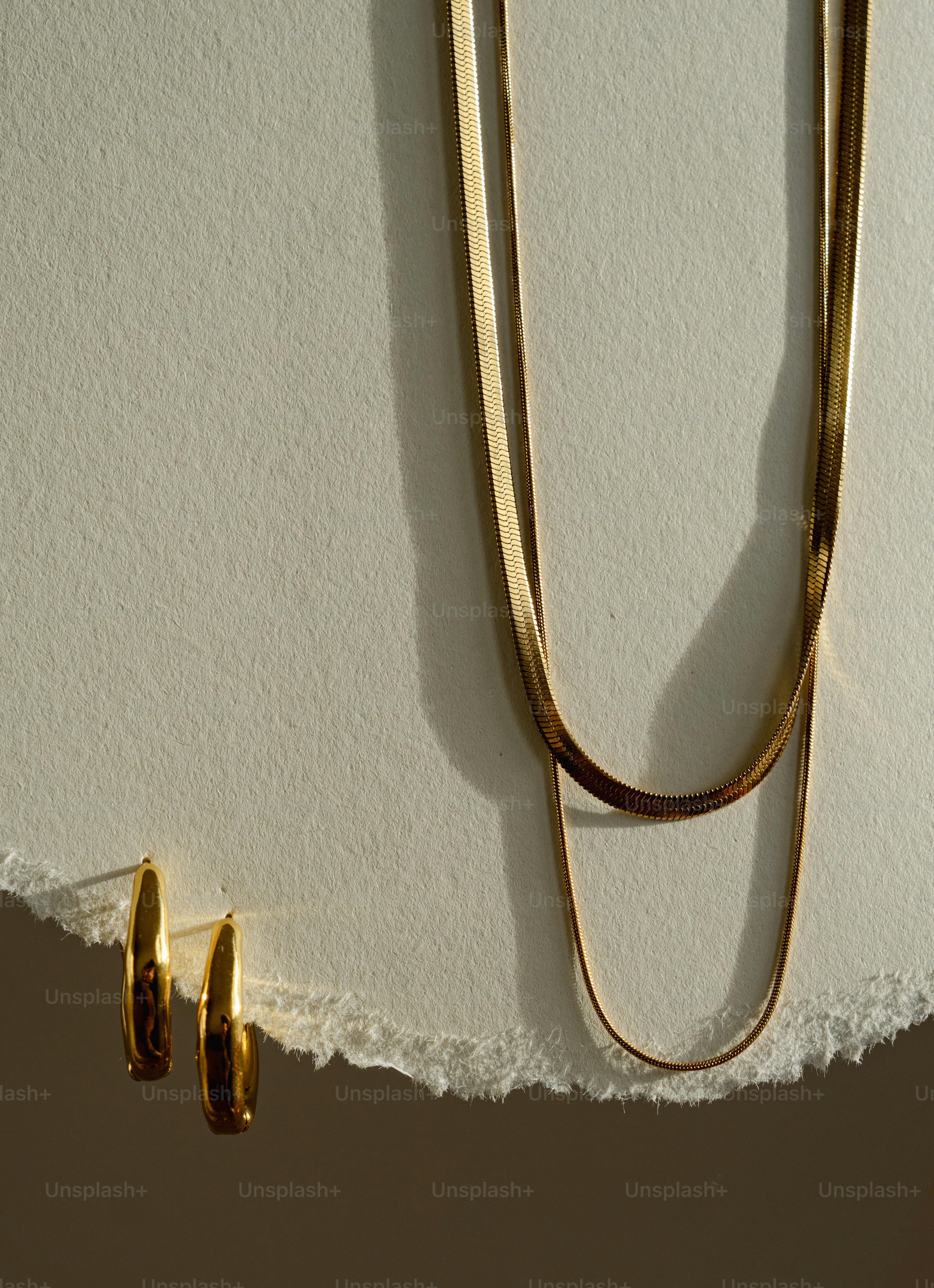 A pair of gold earrings hanging on a wall