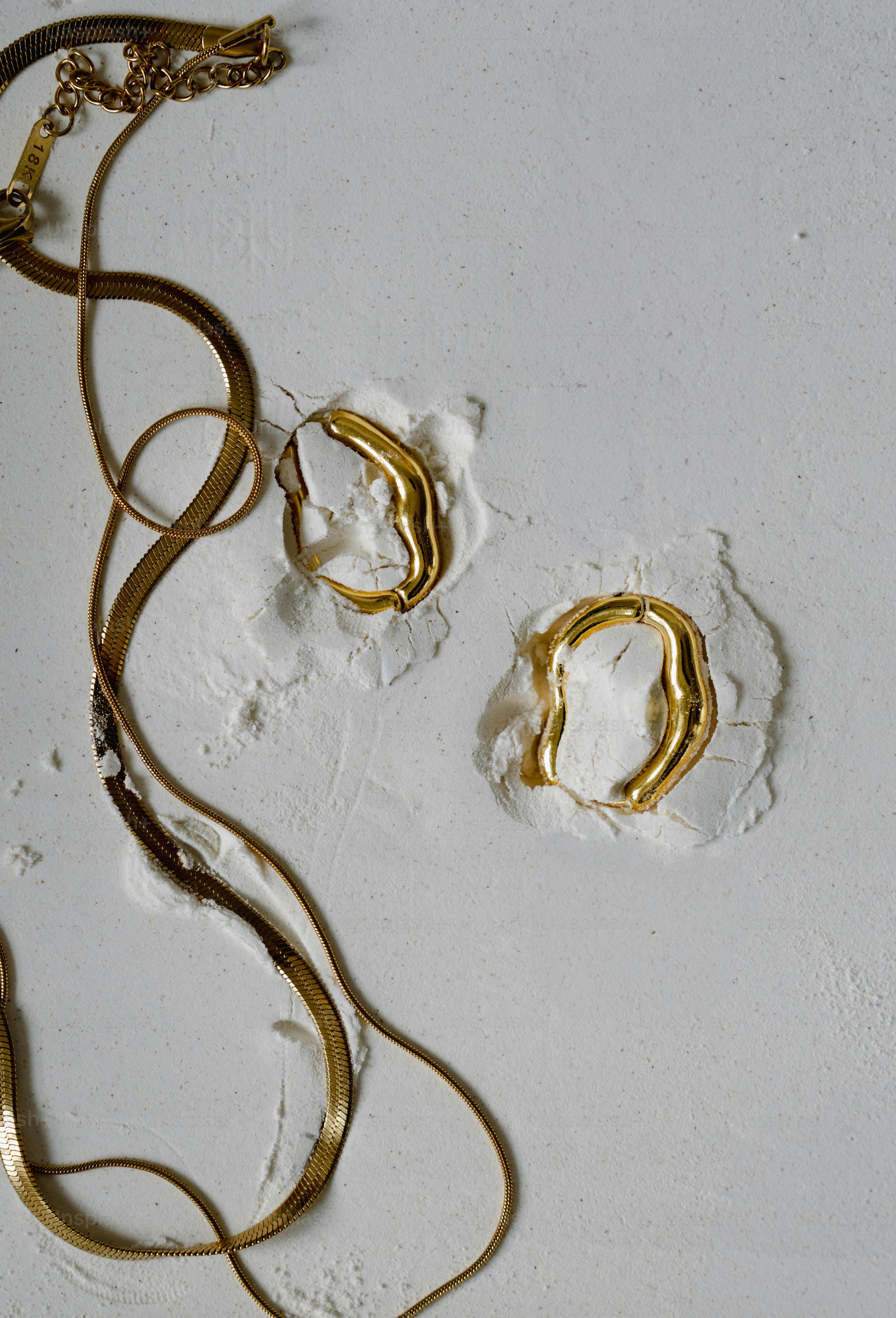 A white wall with a bunch of gold rings on it