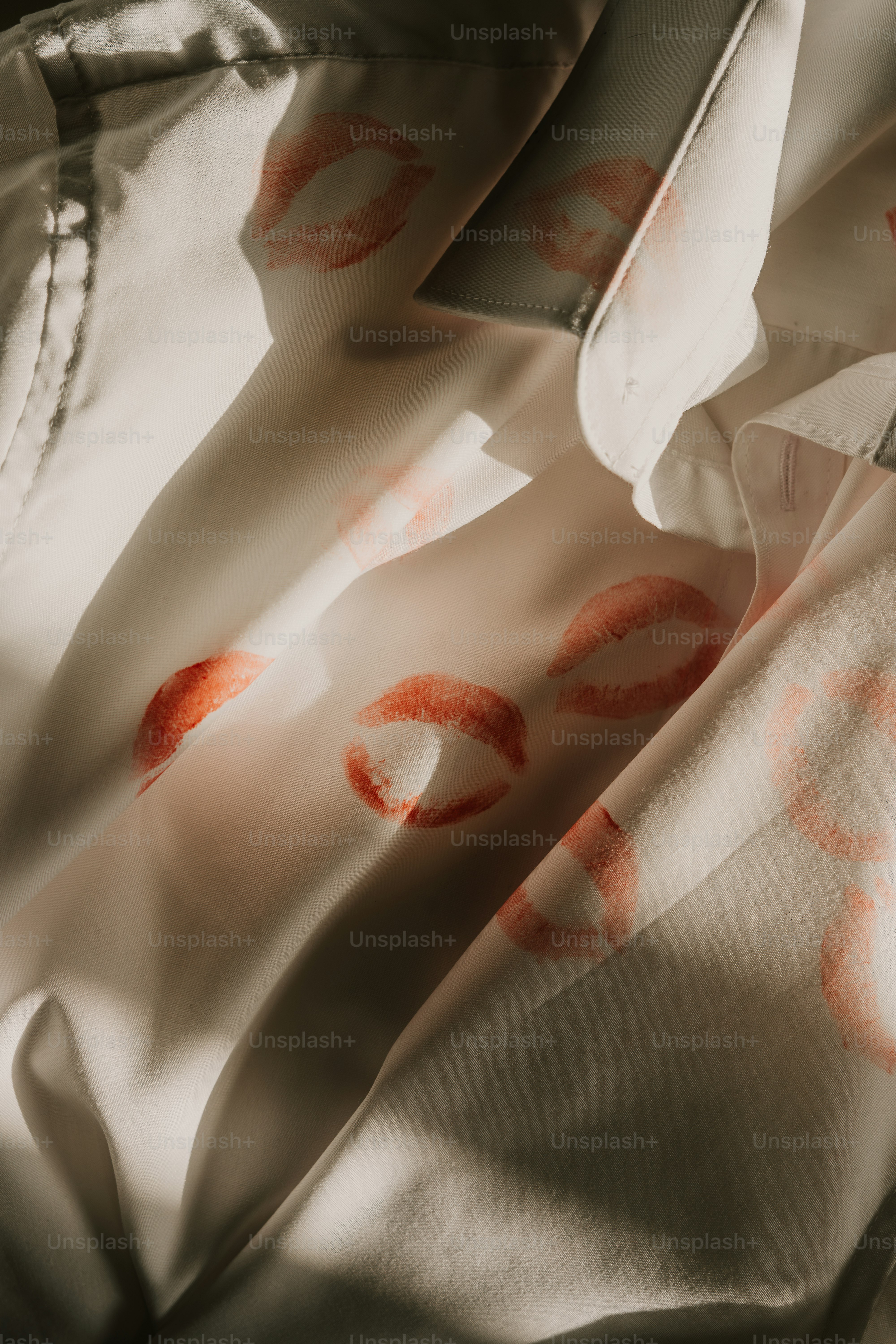 A close up of a shirt with red lips on it