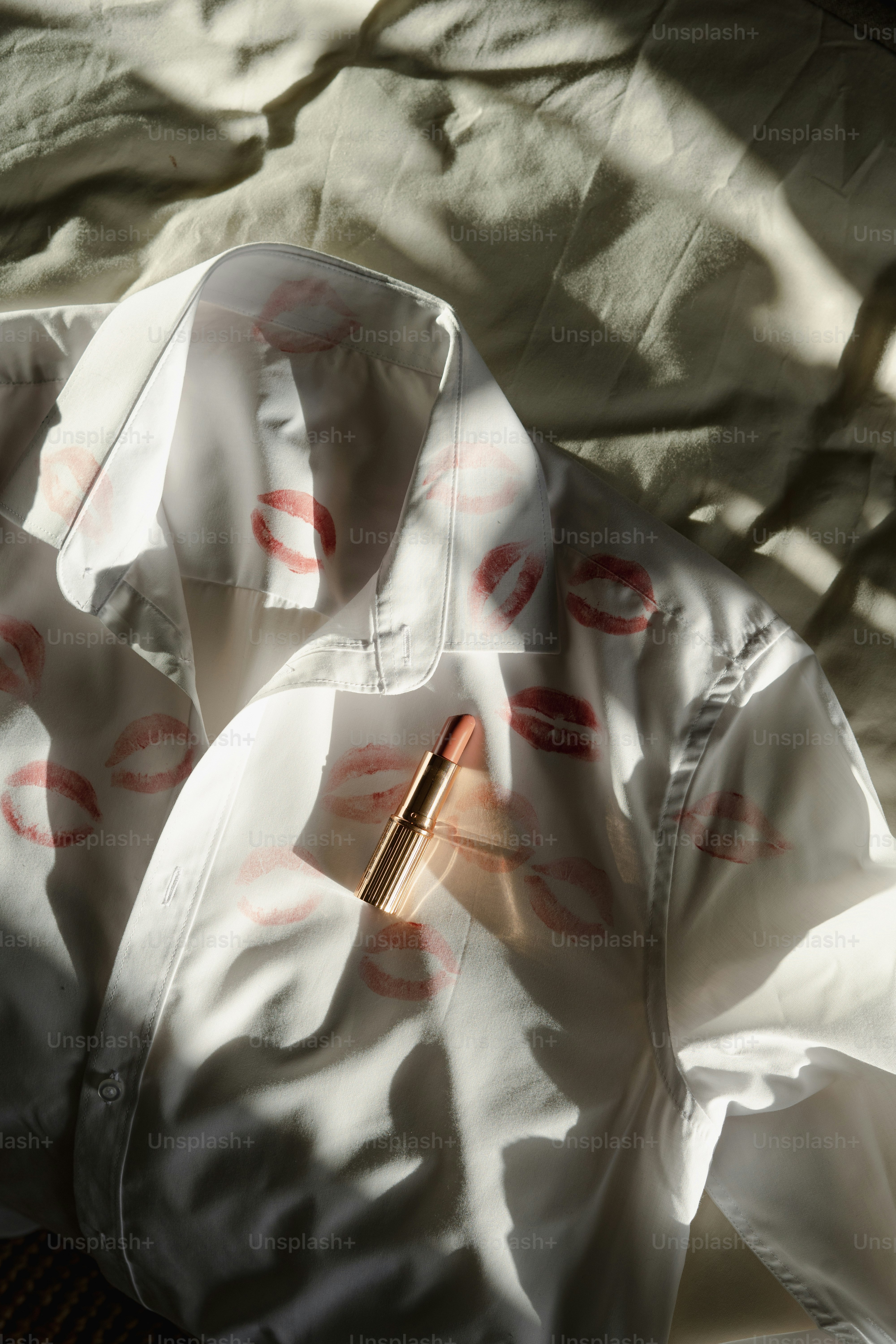 Une chemise blanche avec une écriture rouge dessus, assise sur un lit