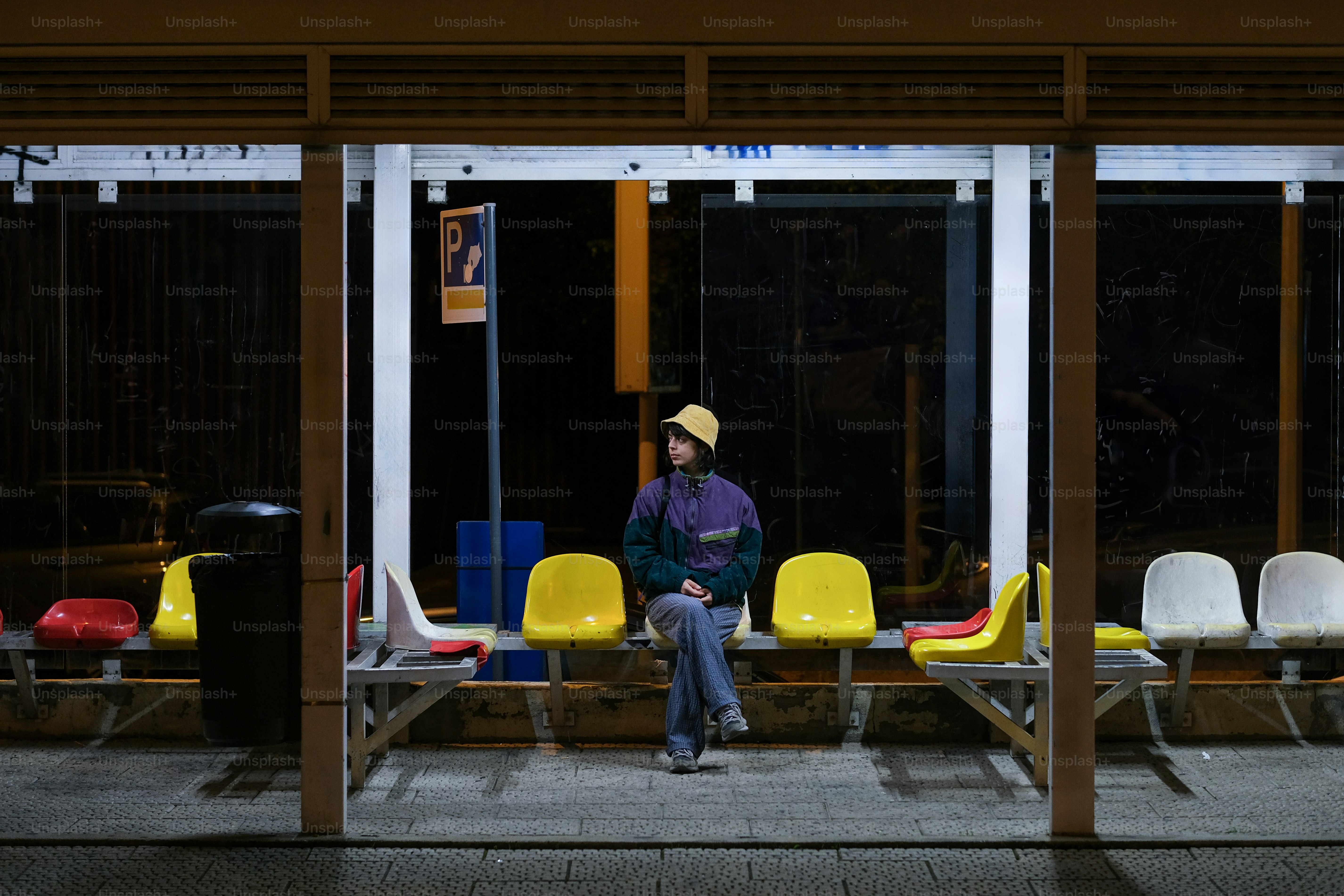 A person sitting on a bench in front of a building photo – Solitude ...