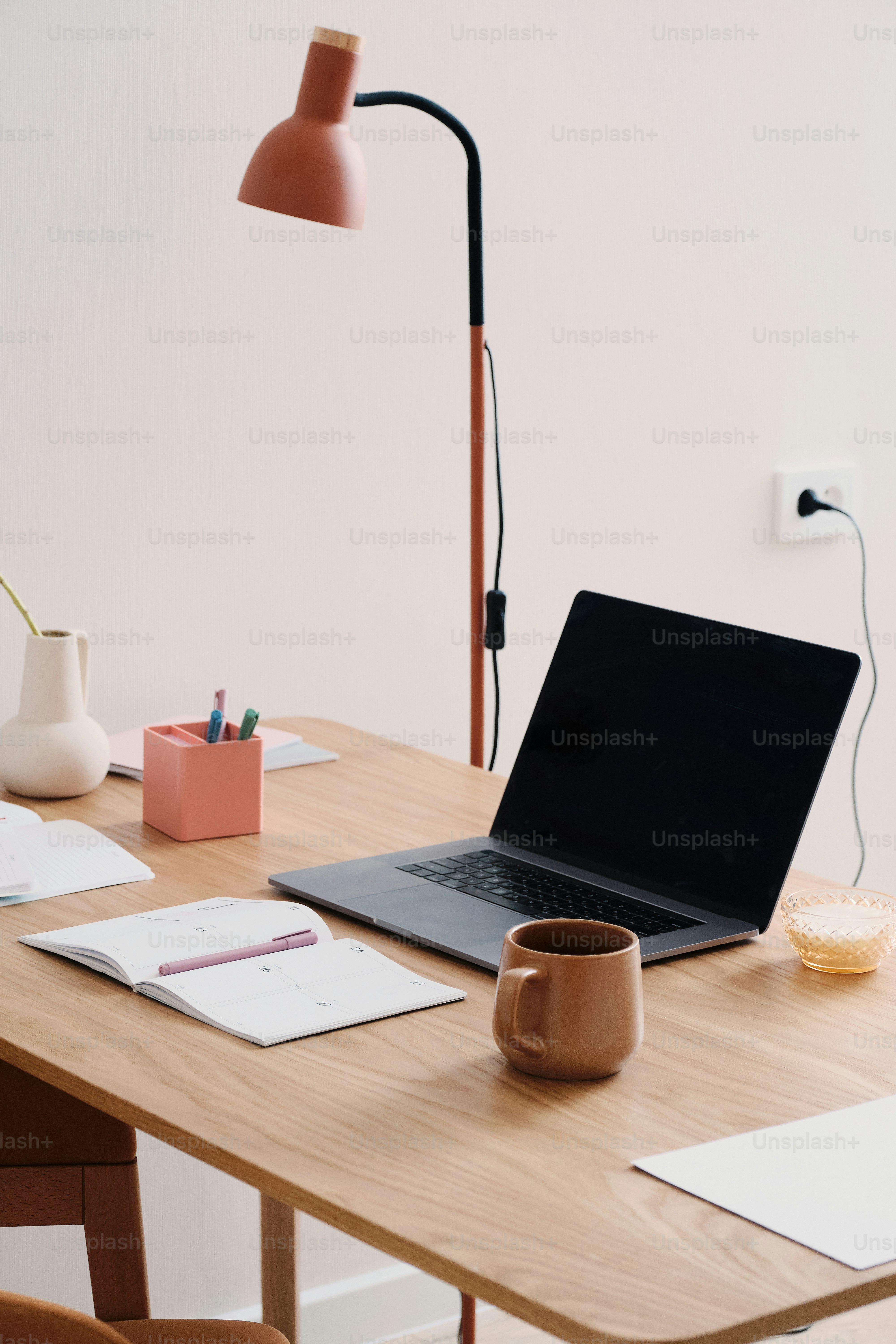A desk with a laptop and a lamp on it