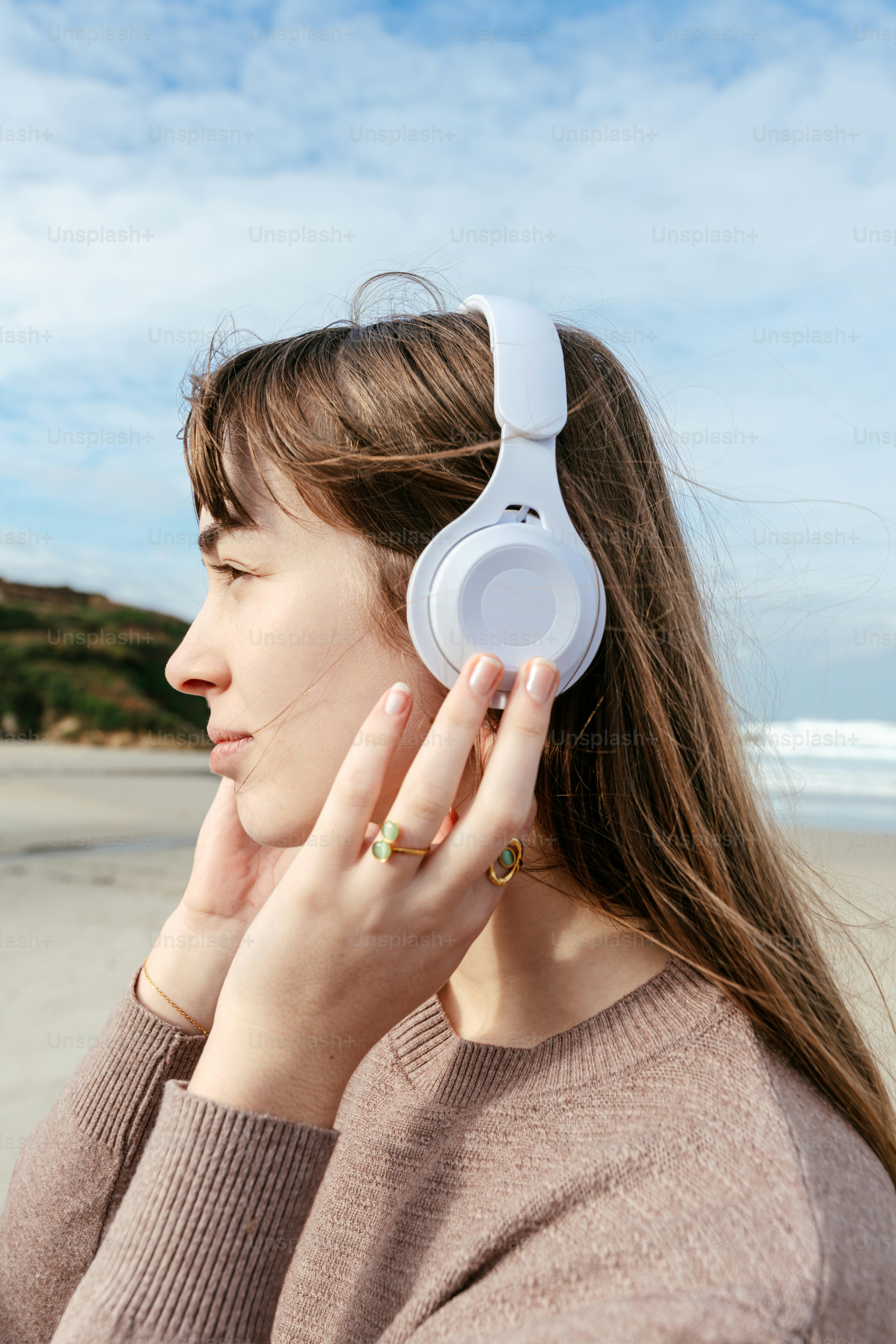 A woman wearing headphones on the beach