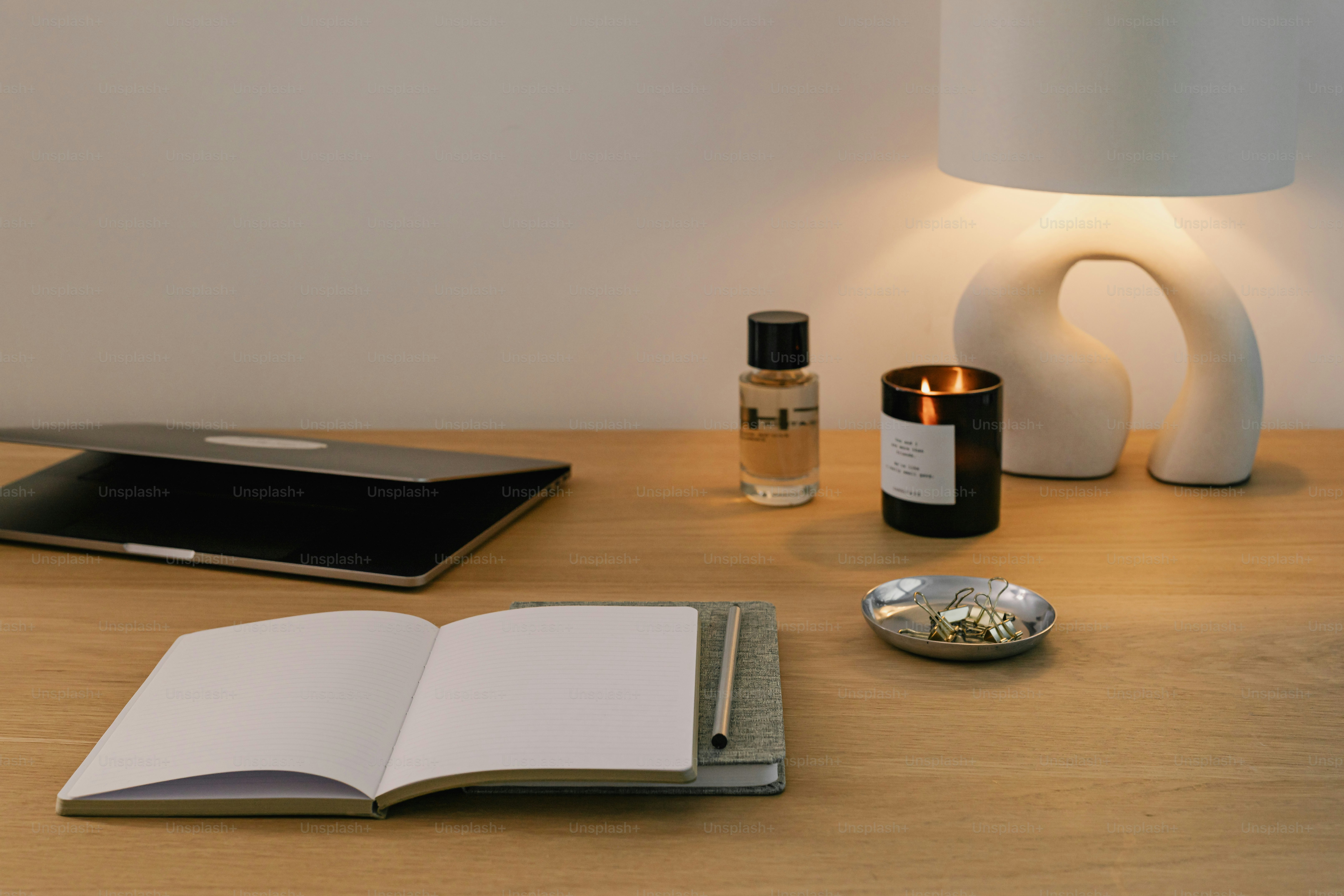 A desk with a lamp, a book and a bottle of wine