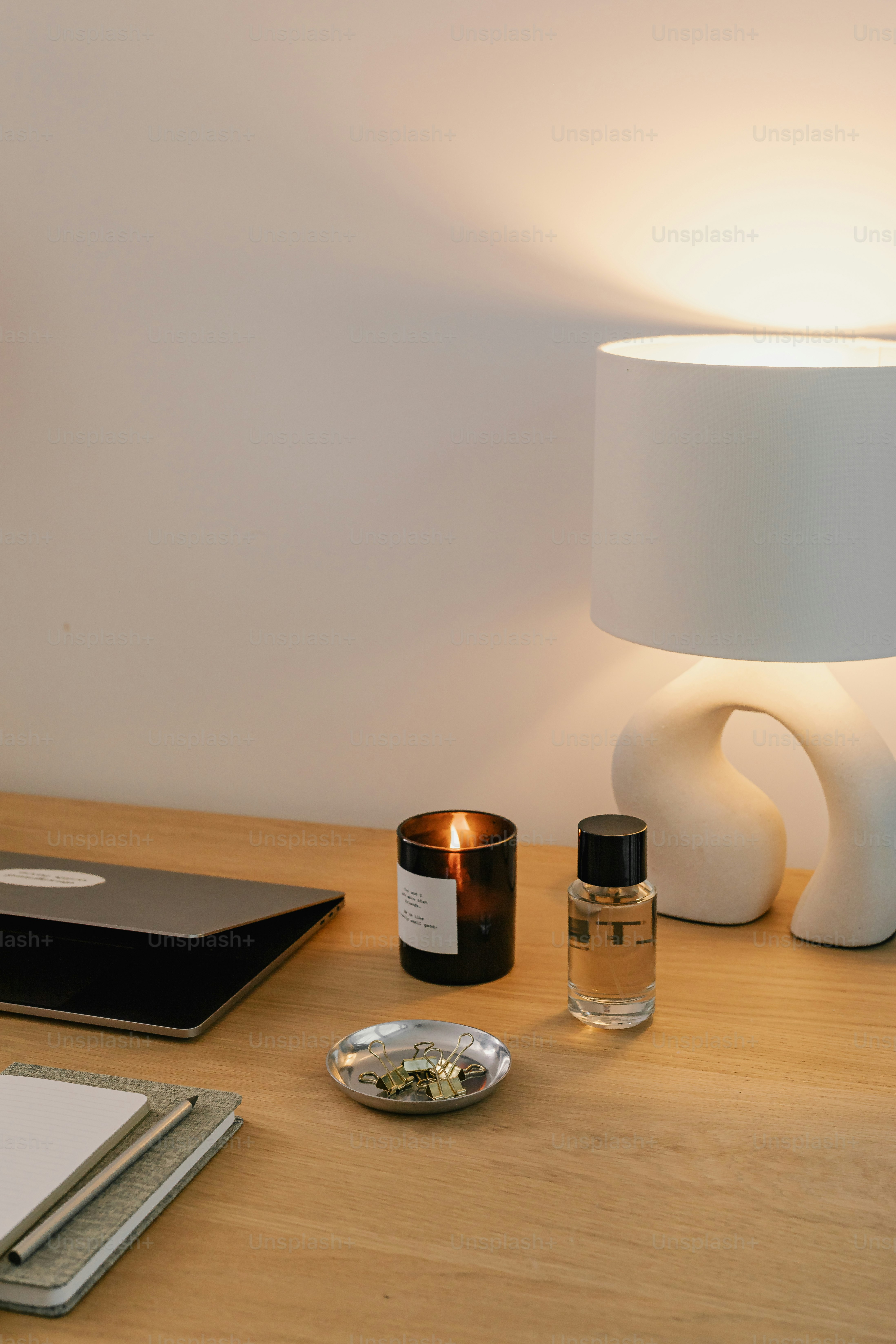 A desk with a lamp, notebooks, and other items on it