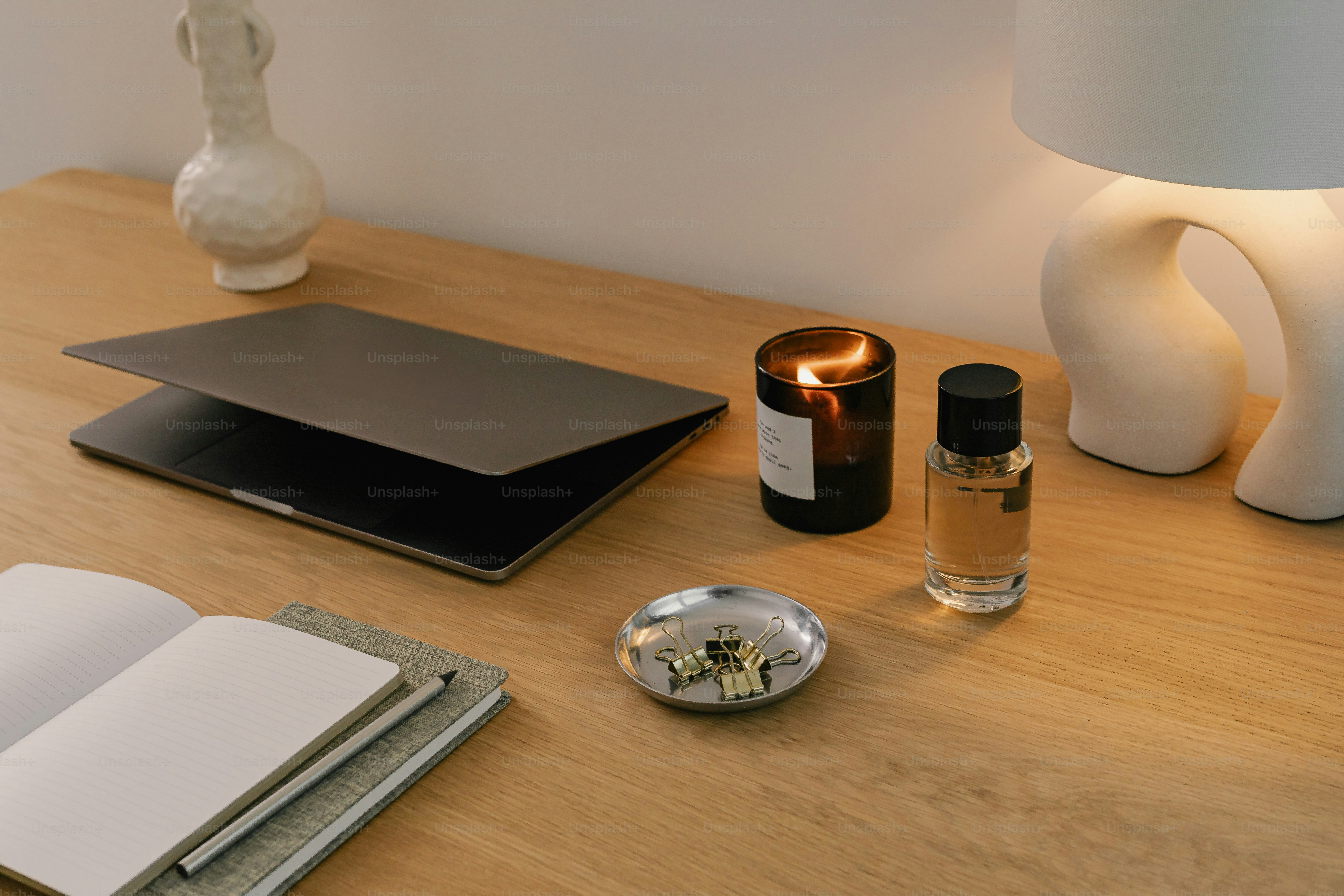 A desk with a lamp, a notebook, and other items