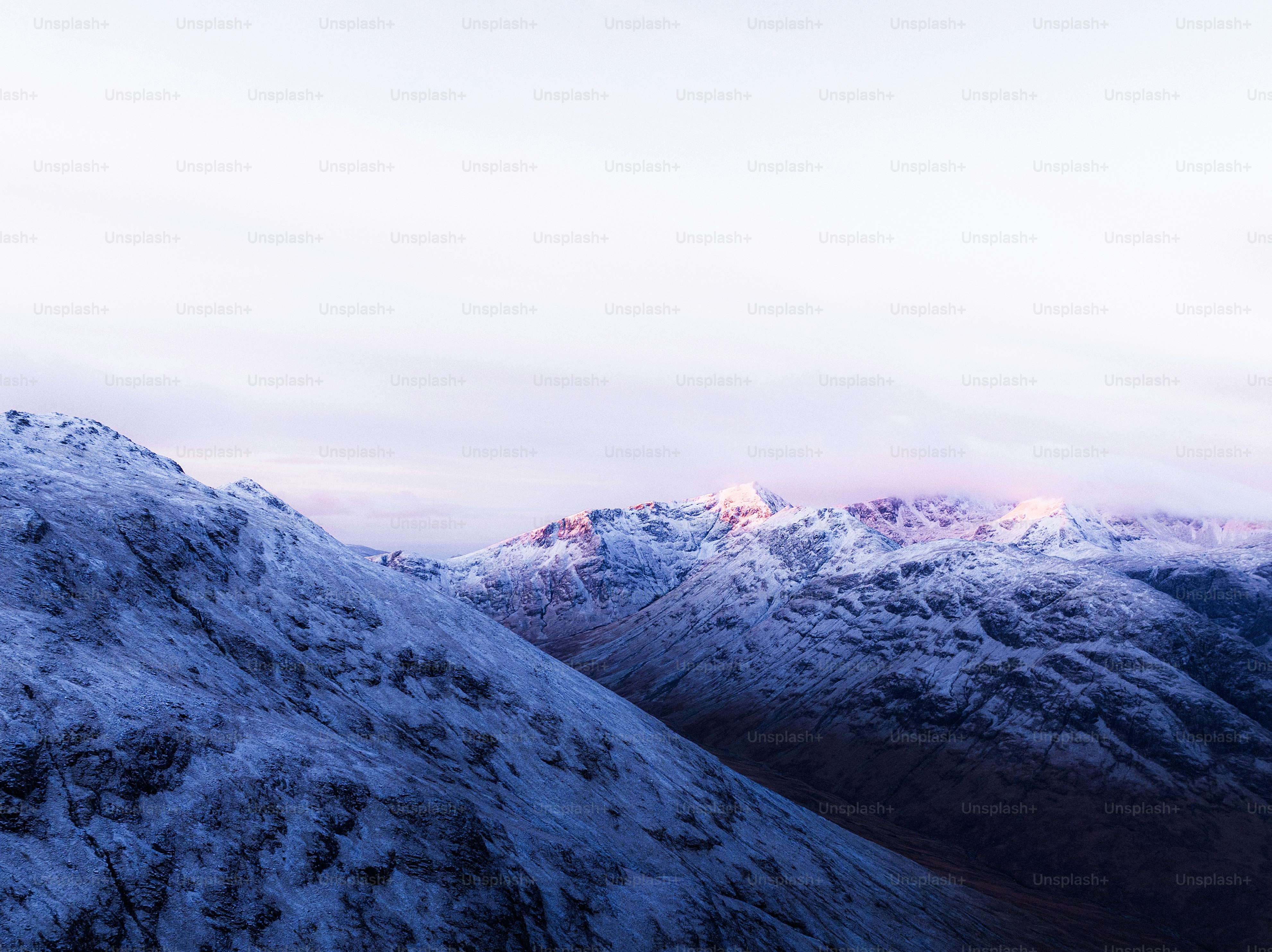 A mountain covered in snow under a blue sky