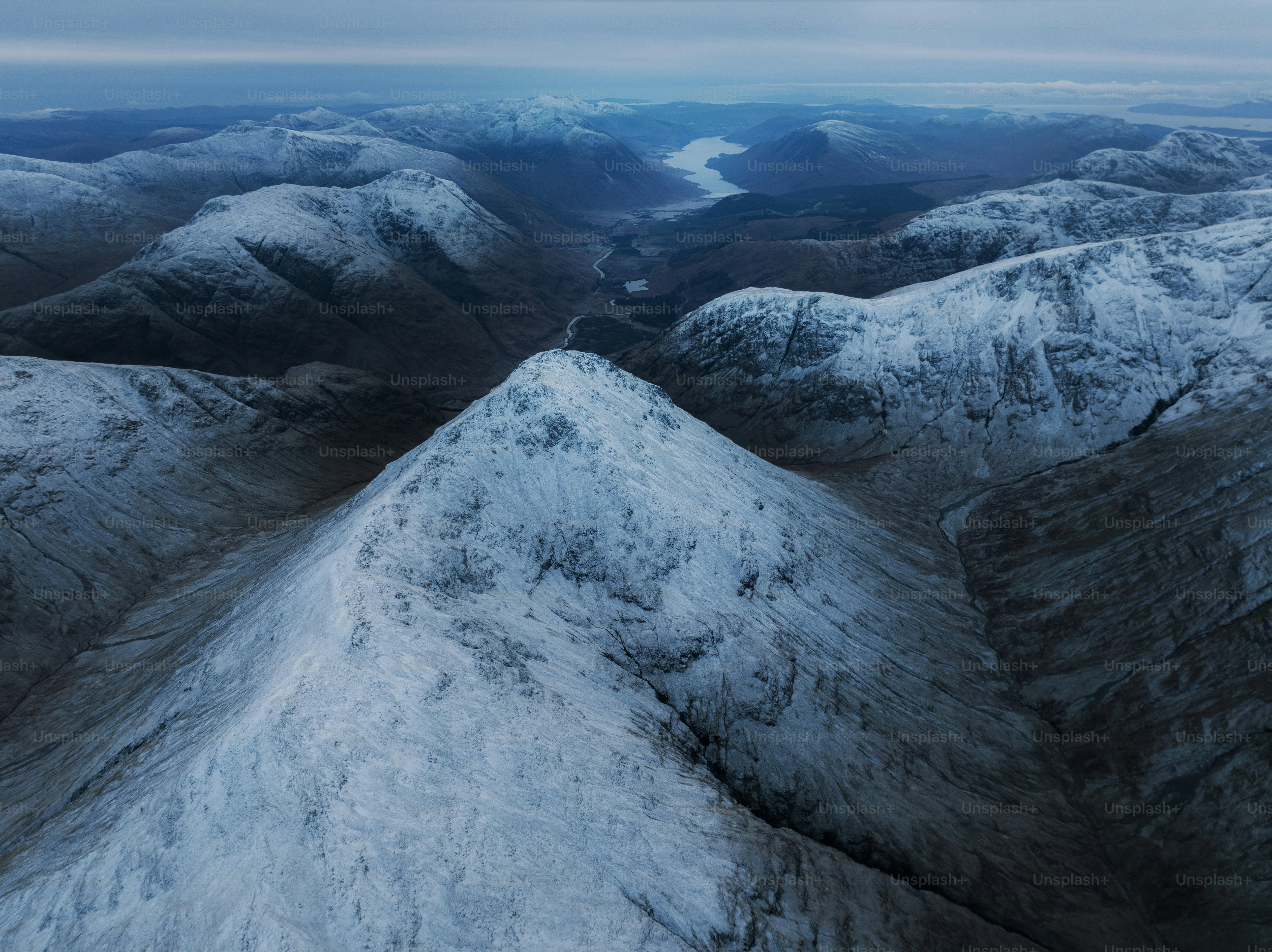 An aerial view of a mountain range covered in snow