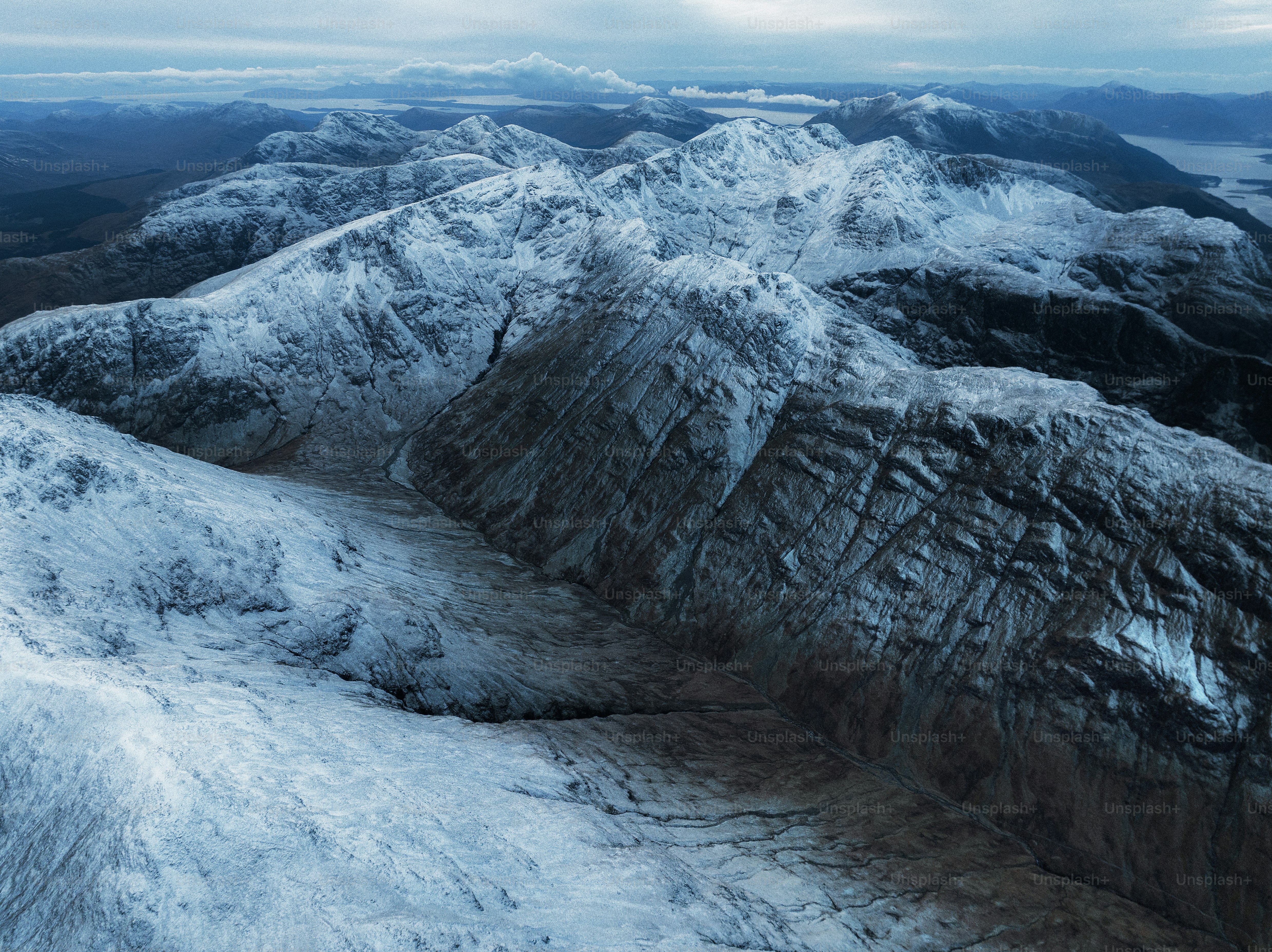An aerial view of a mountain range covered in snow