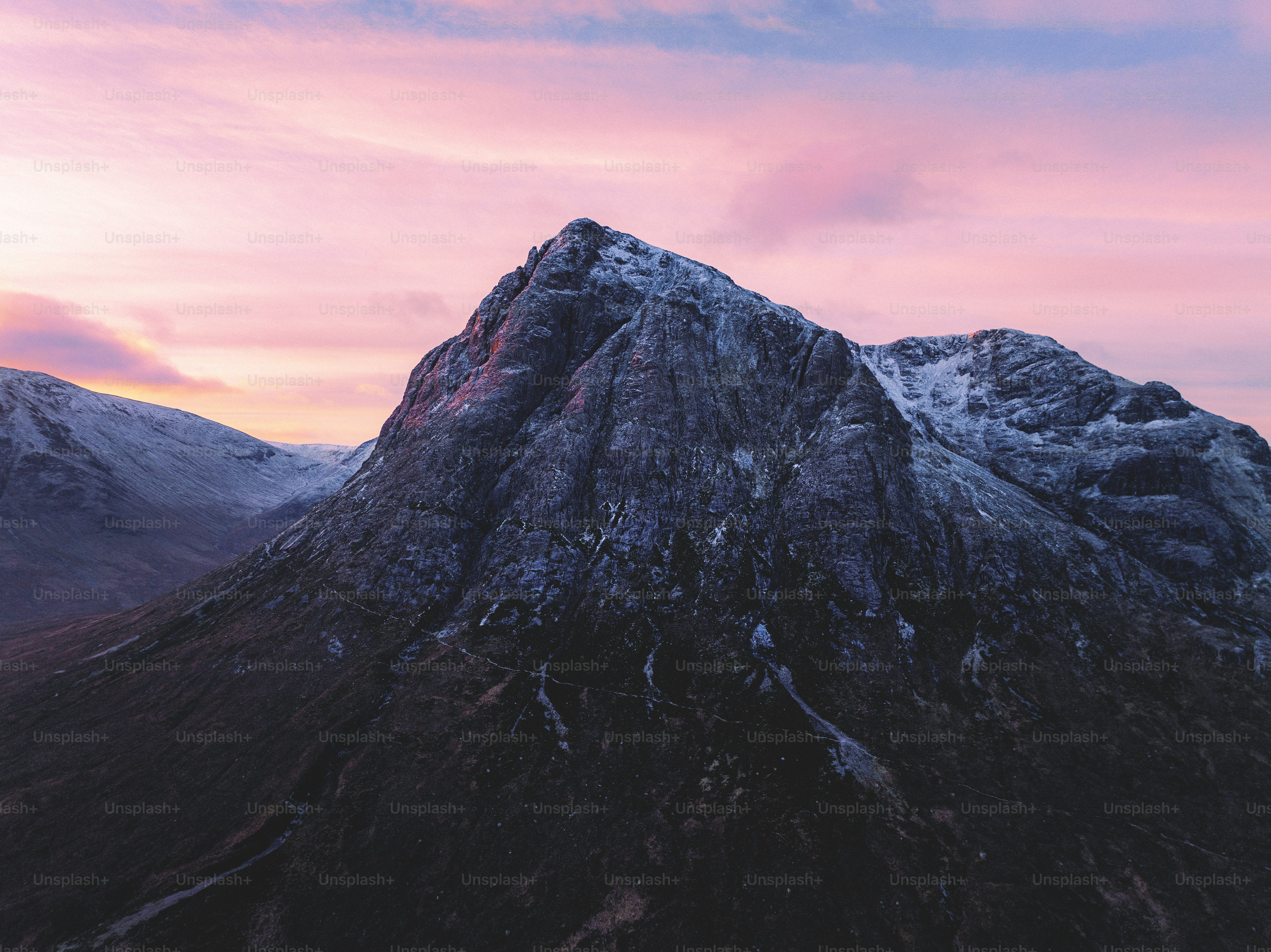 A mountain with a pink sky in the background