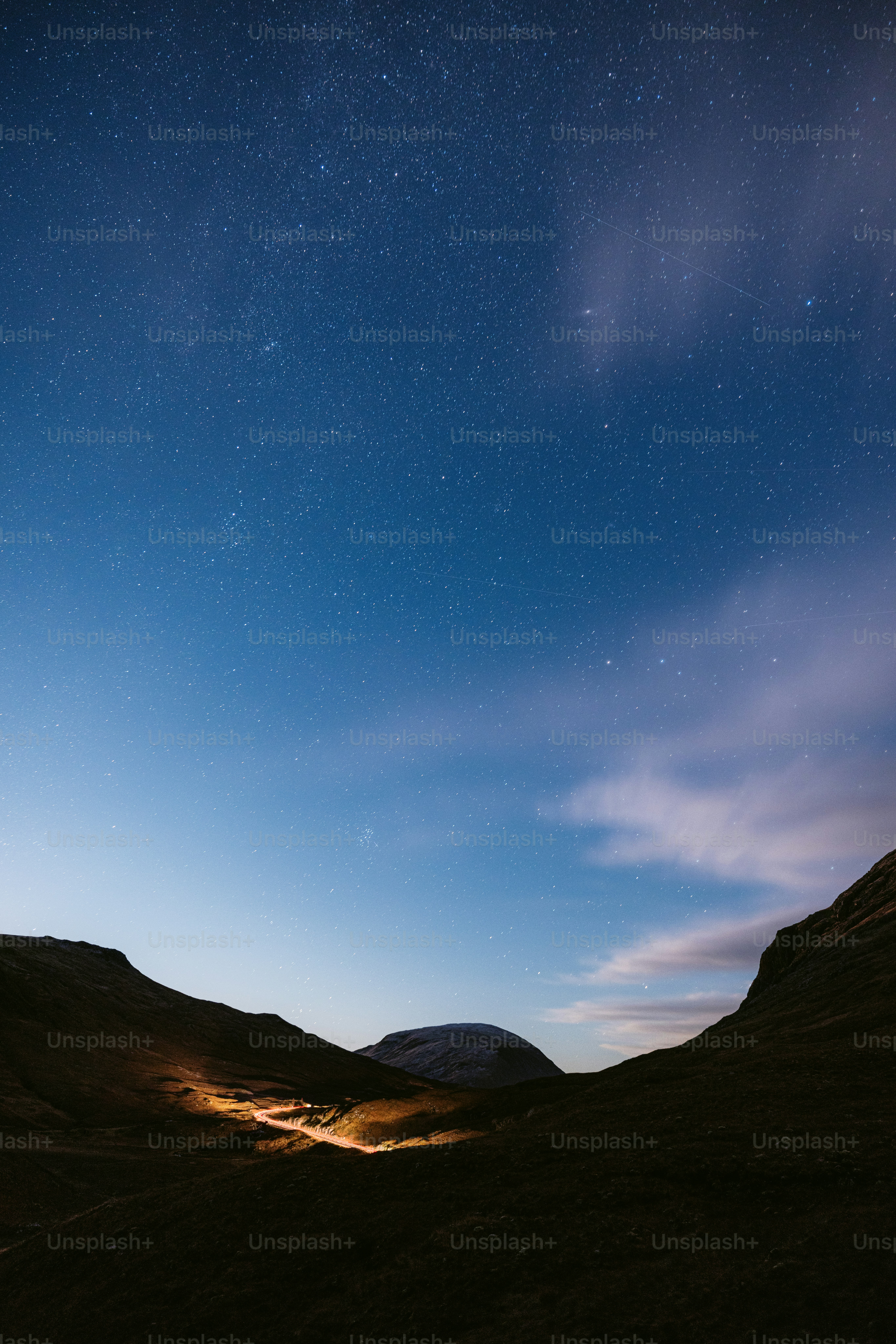 The night sky with stars above a mountain range