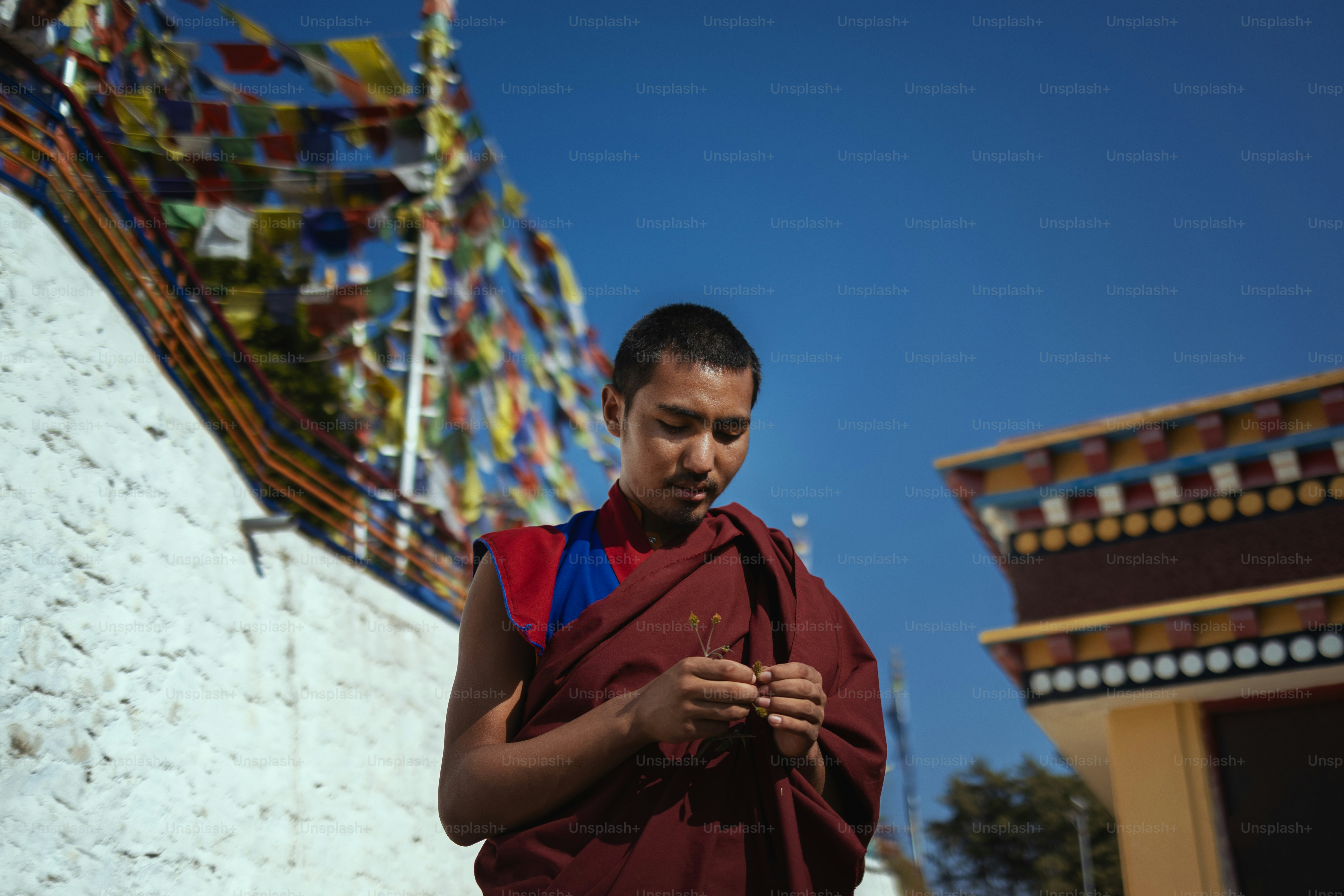 Un hombre parado frente a un edificio mirando su teléfono celular