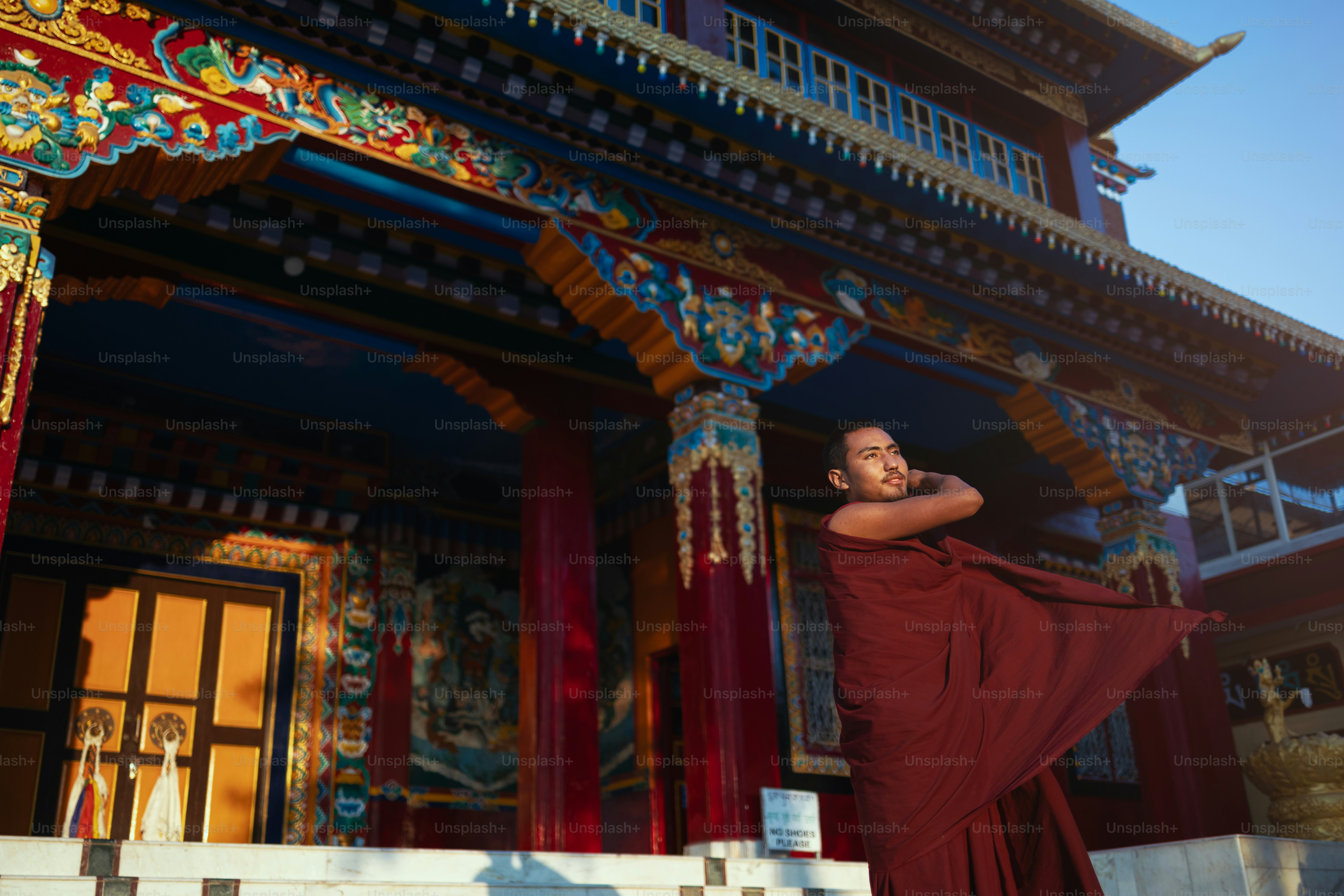A woman in a red dress standing in front of a building photo ...