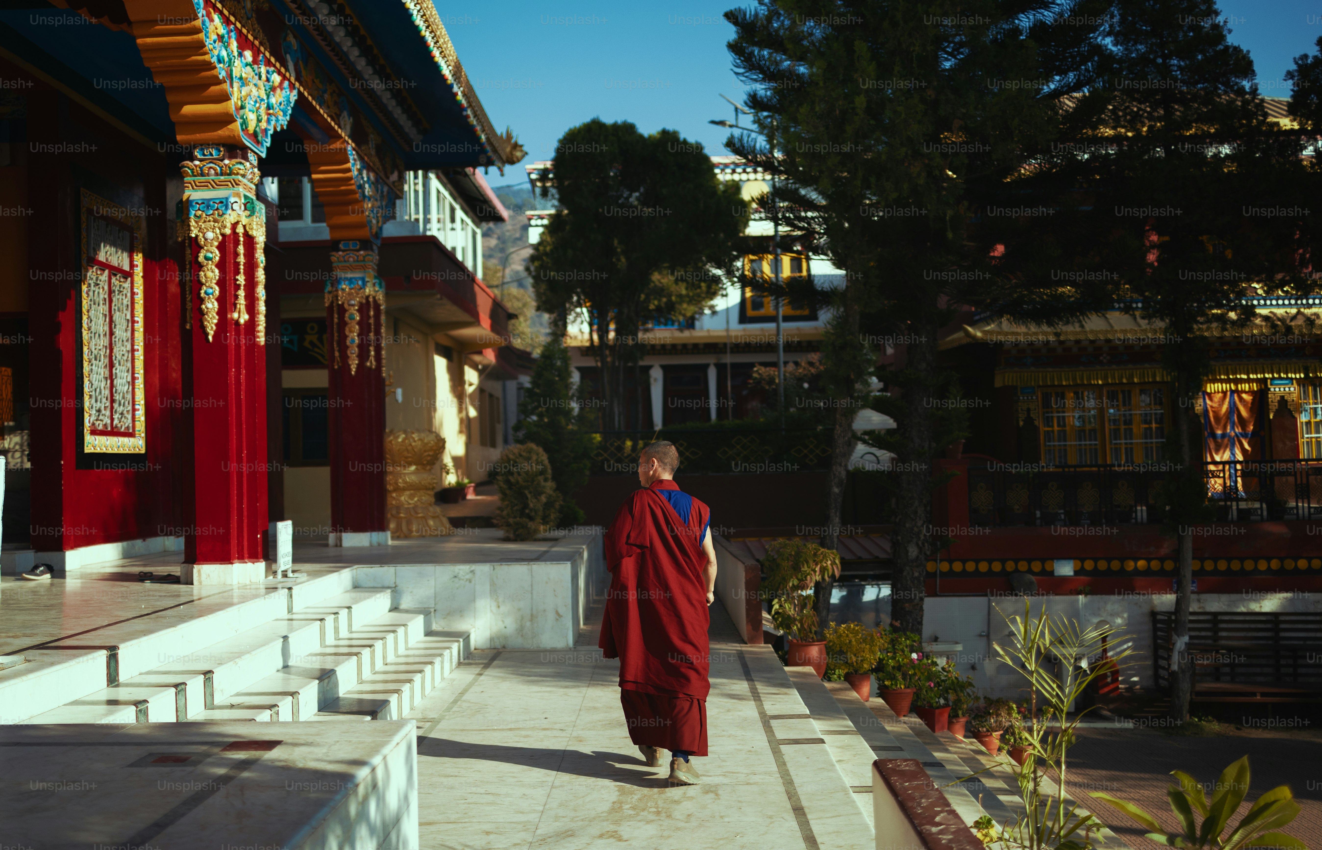 Una persona con una túnica roja caminando por una calle
