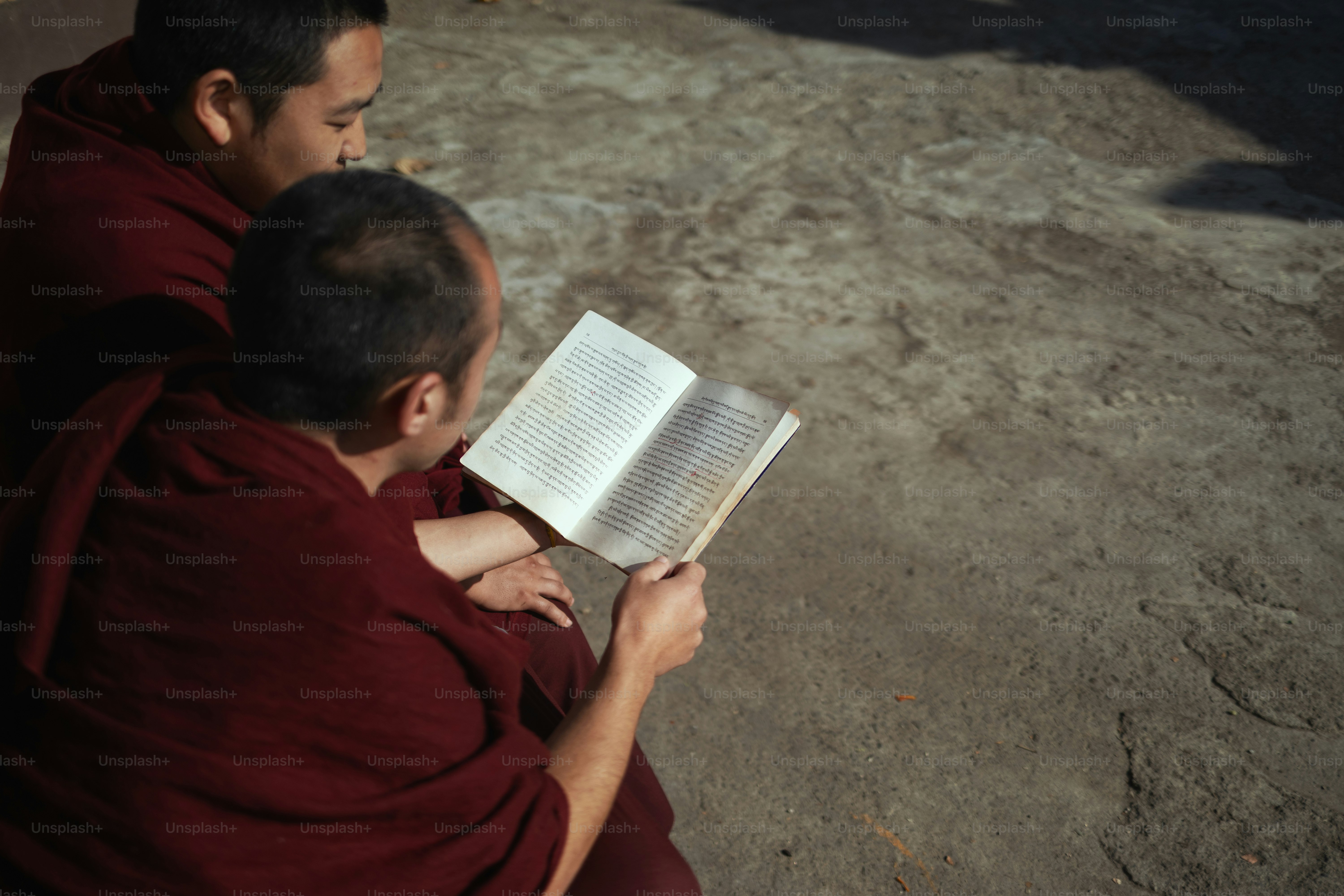 A man in a red robe reading a book