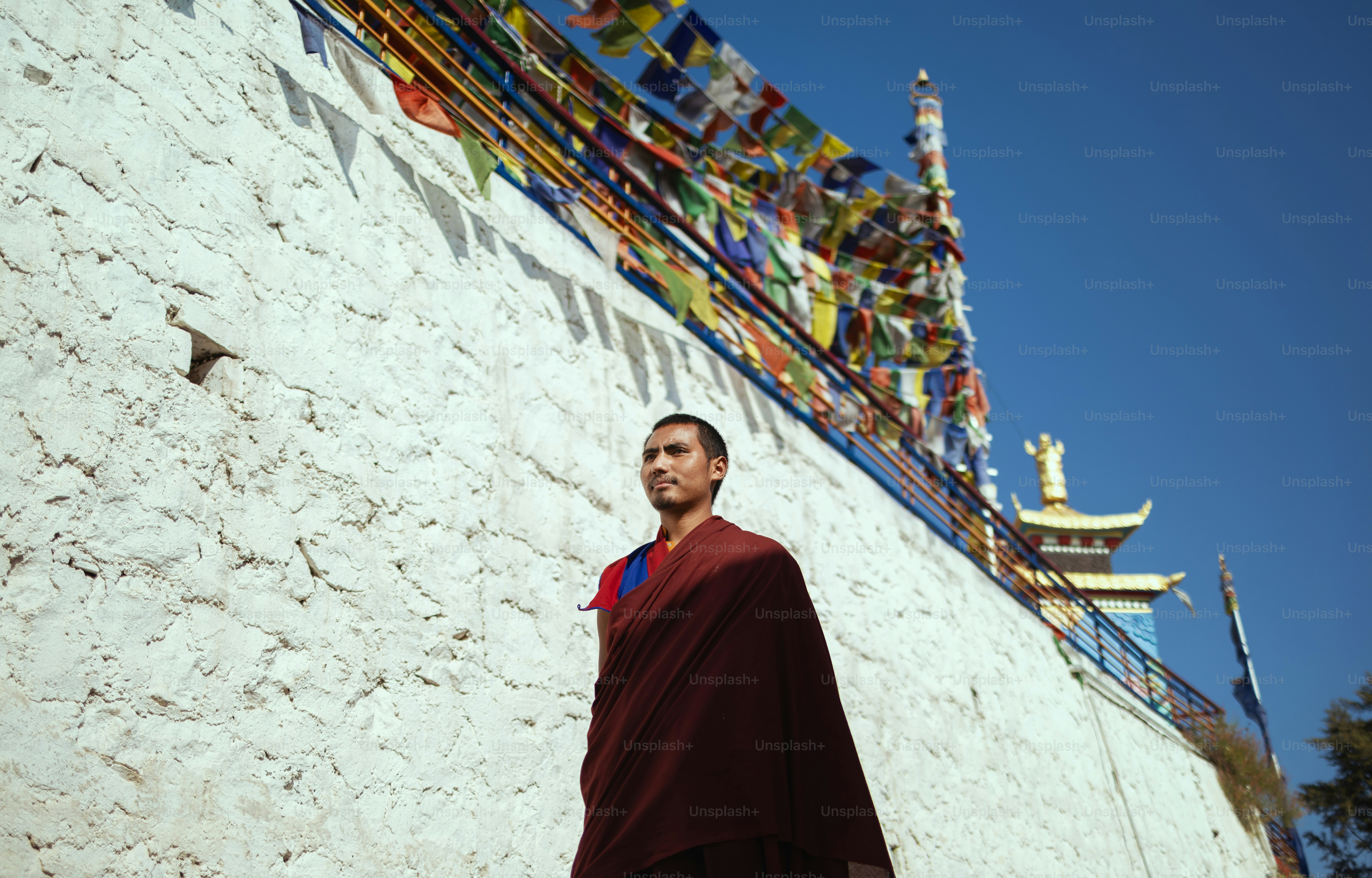 Un hombre de pie frente a una pared blanca