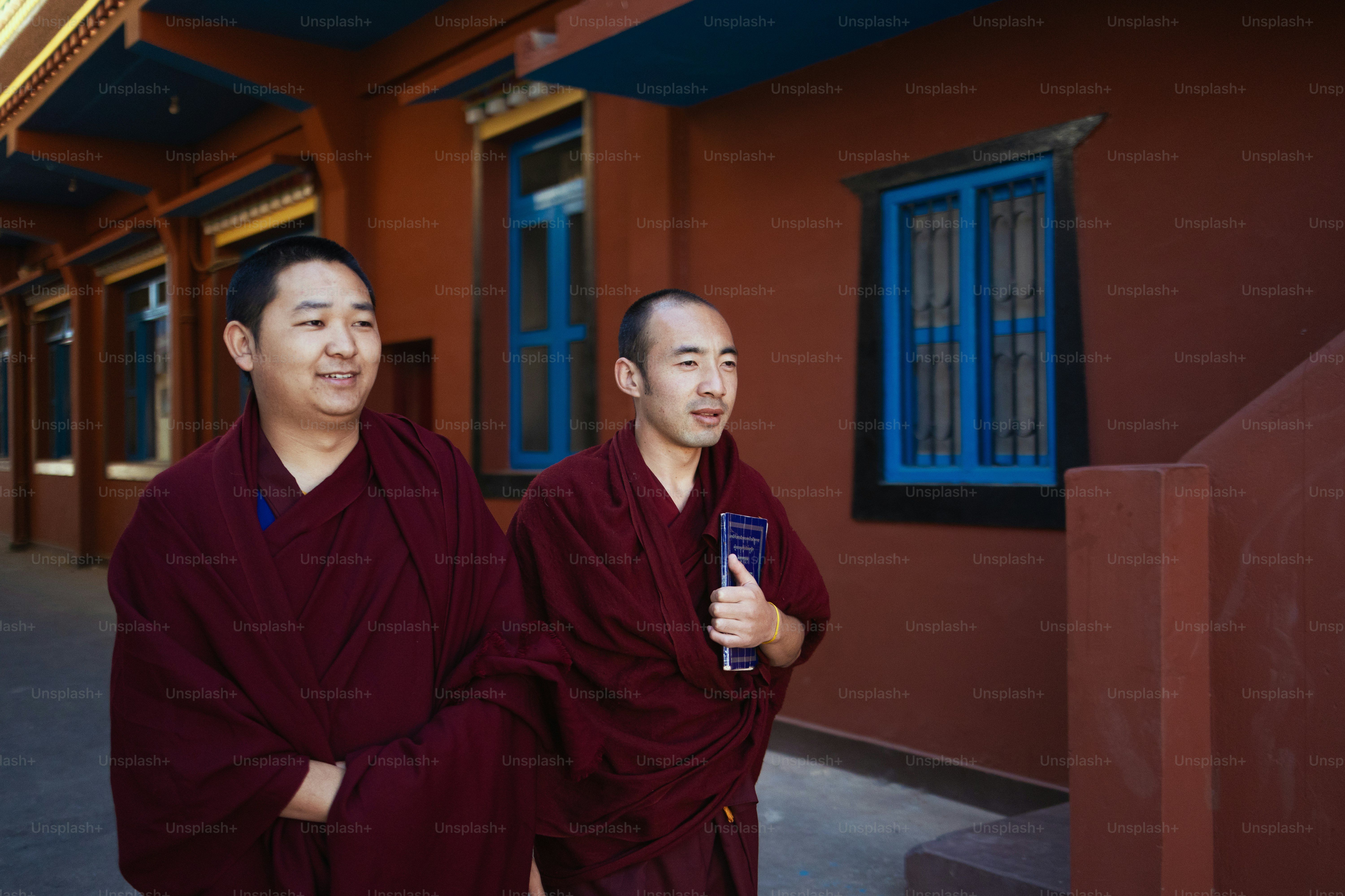 Two men standing next to each other in front of a building photo ...