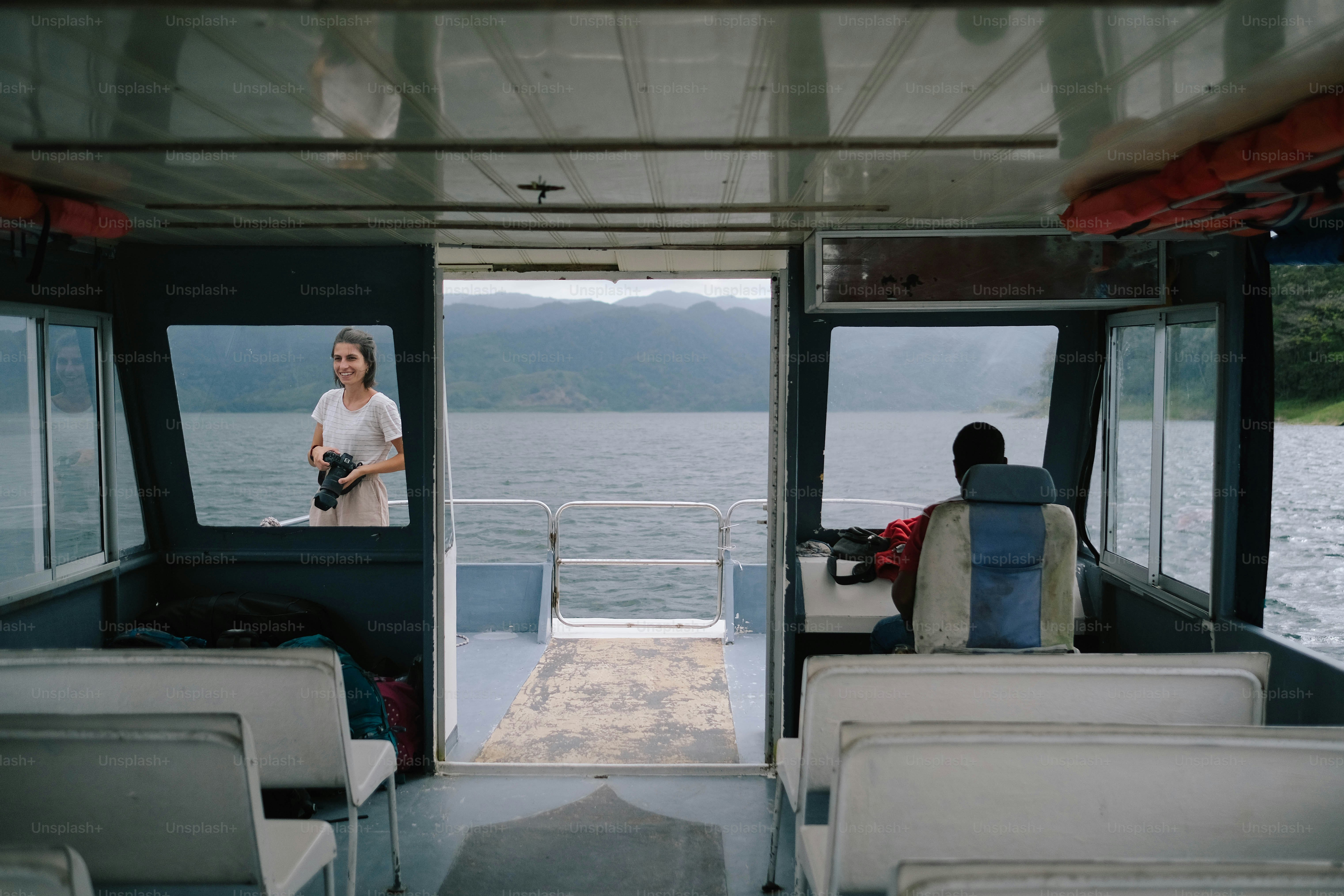 A woman standing on a boat looking out at the water