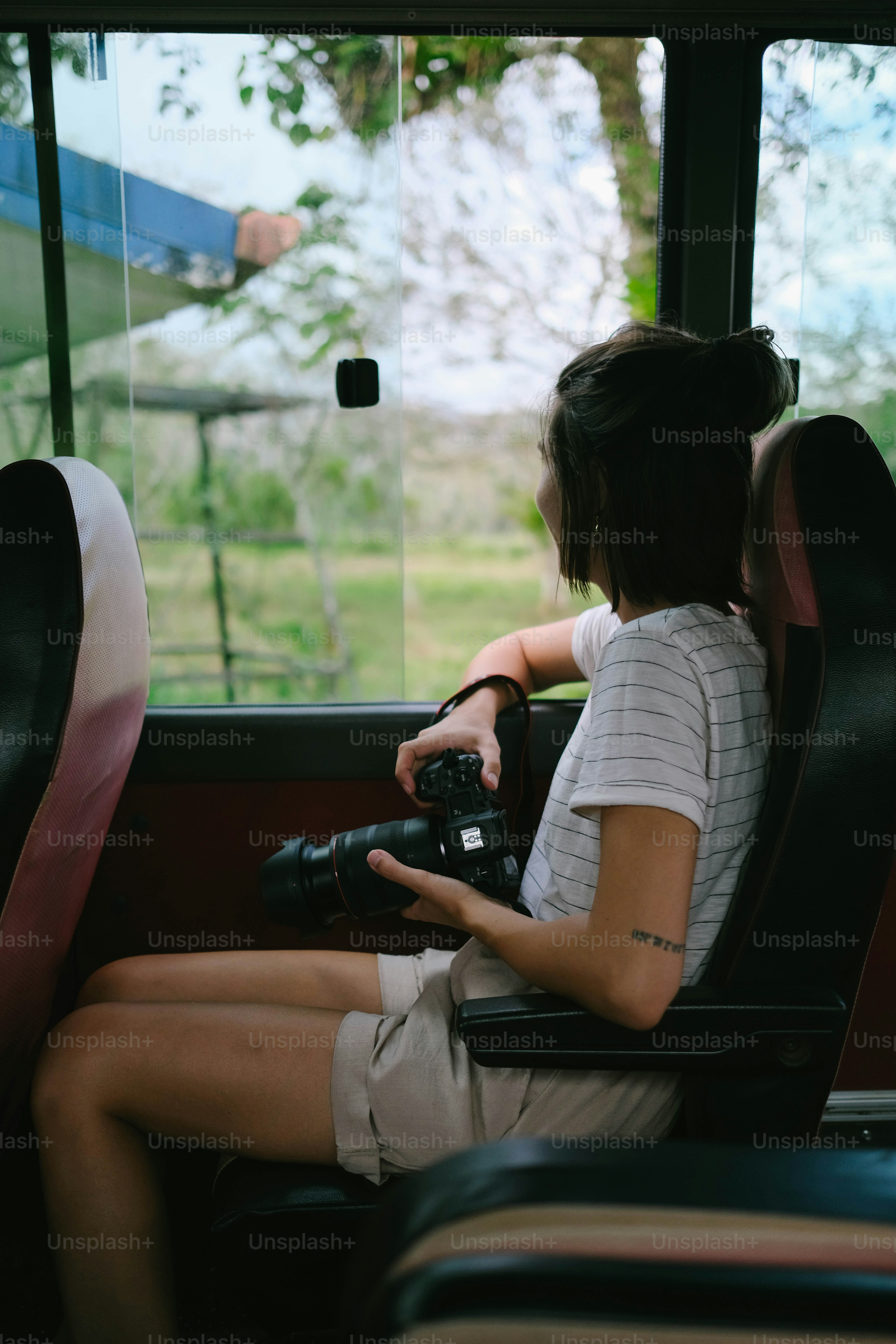 A woman sitting on a bus holding a camera