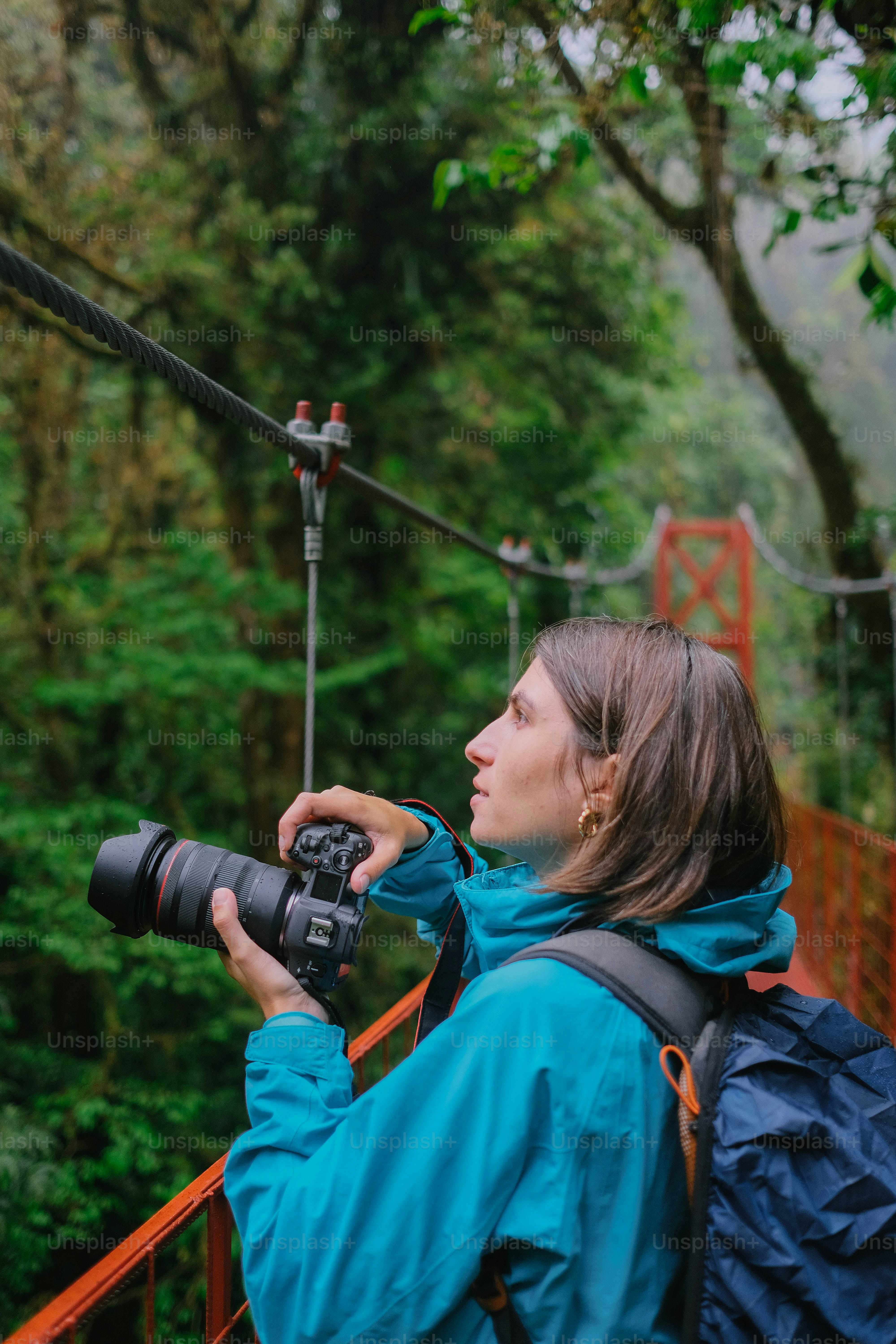 Uma mulher com uma câmera tirando uma foto de uma ponte