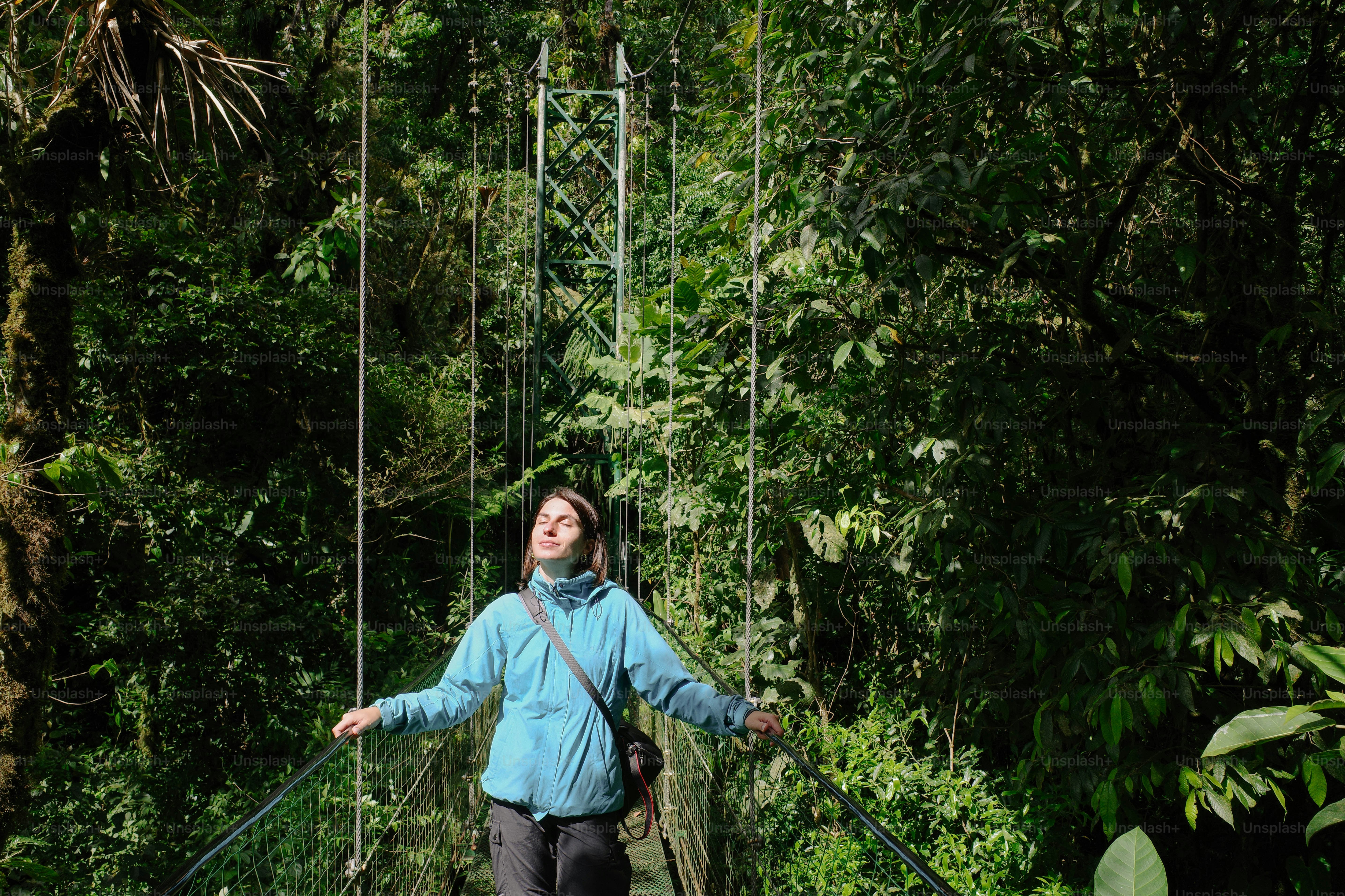 A woman crossing a suspension bridge in the jungle