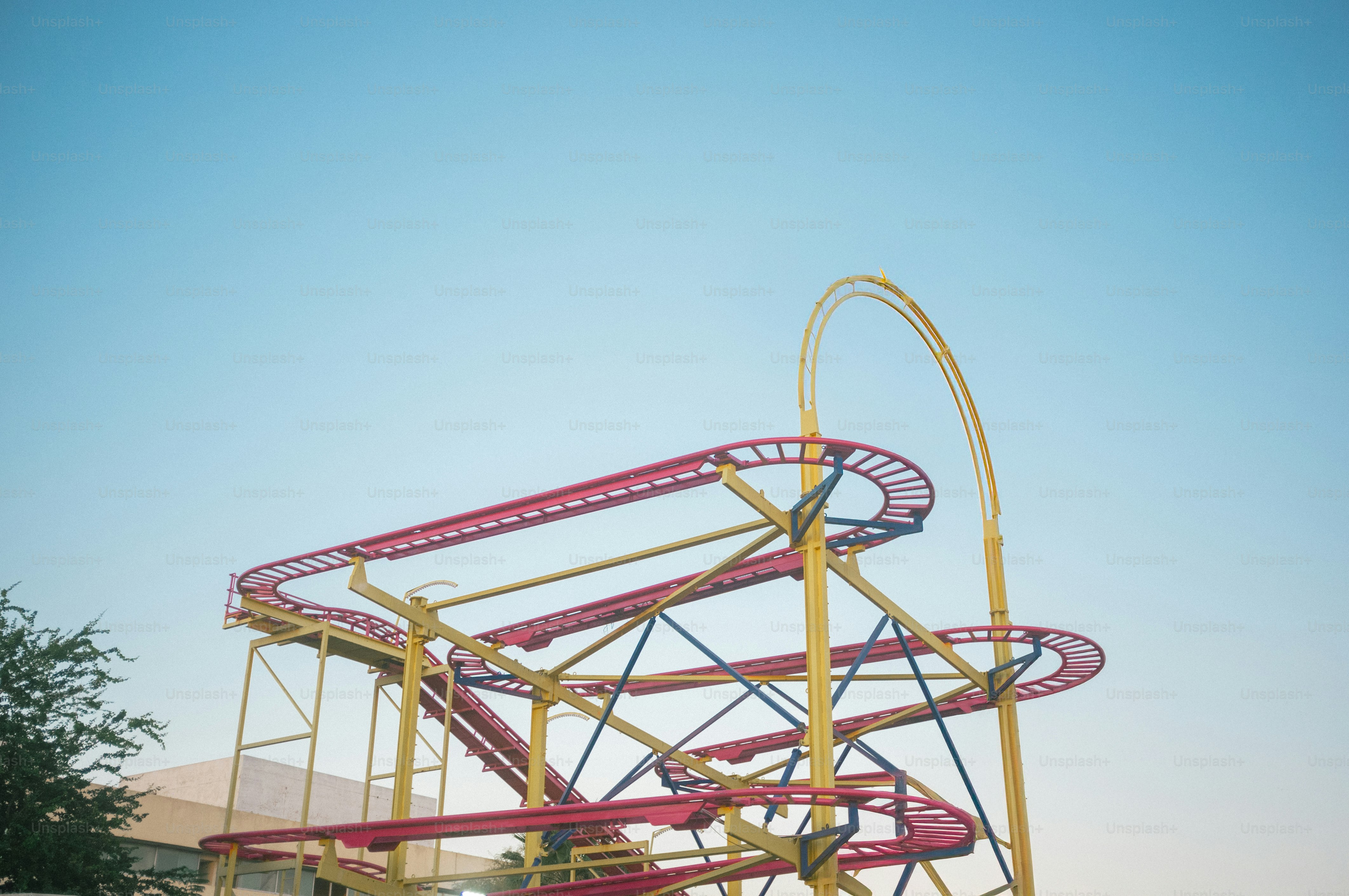 A roller coaster ride with pink flowers on it photo – Amusement park ...