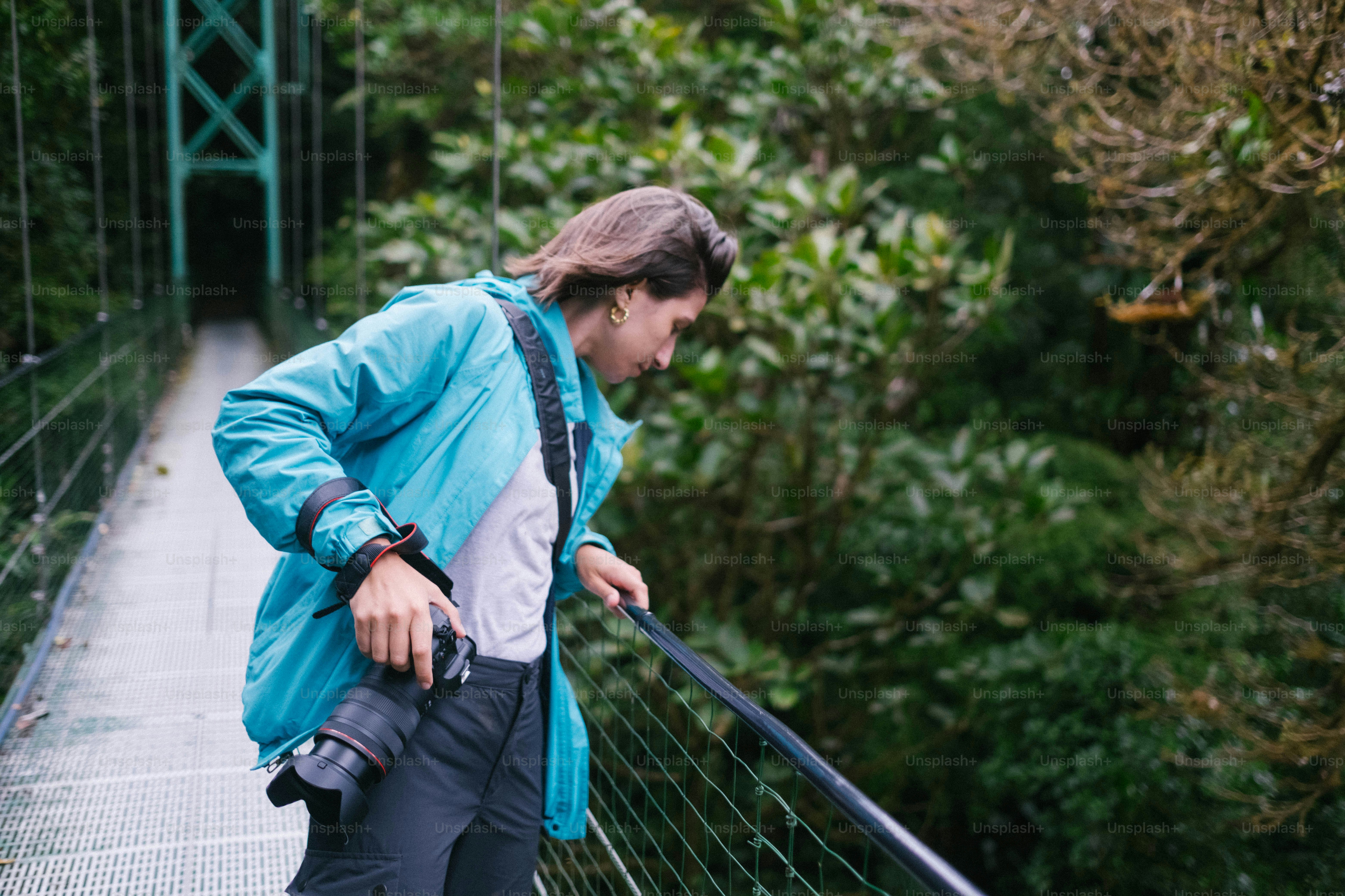 A woman walking across a suspension bridge in the forest