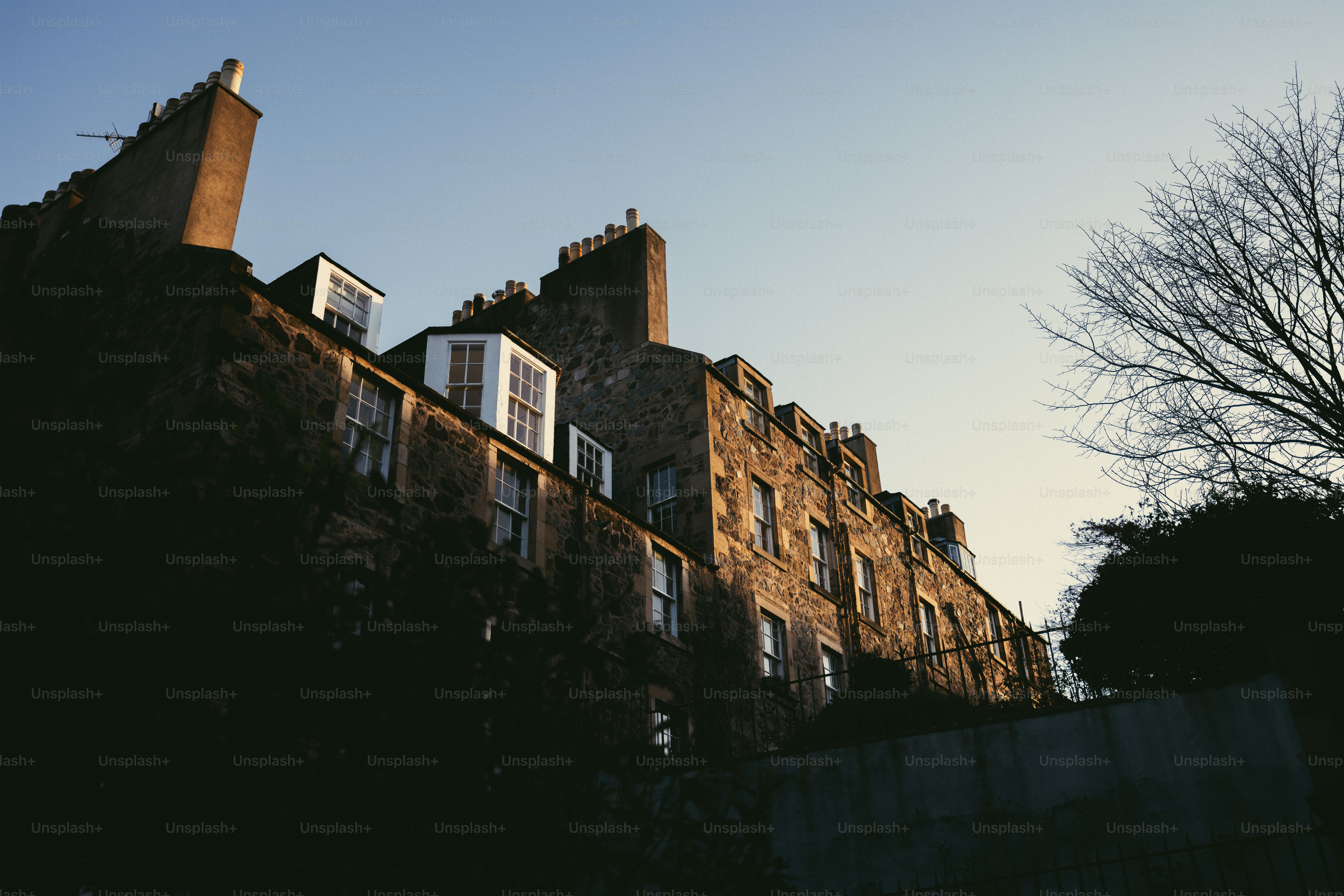 A tall brick building sitting next to a tree