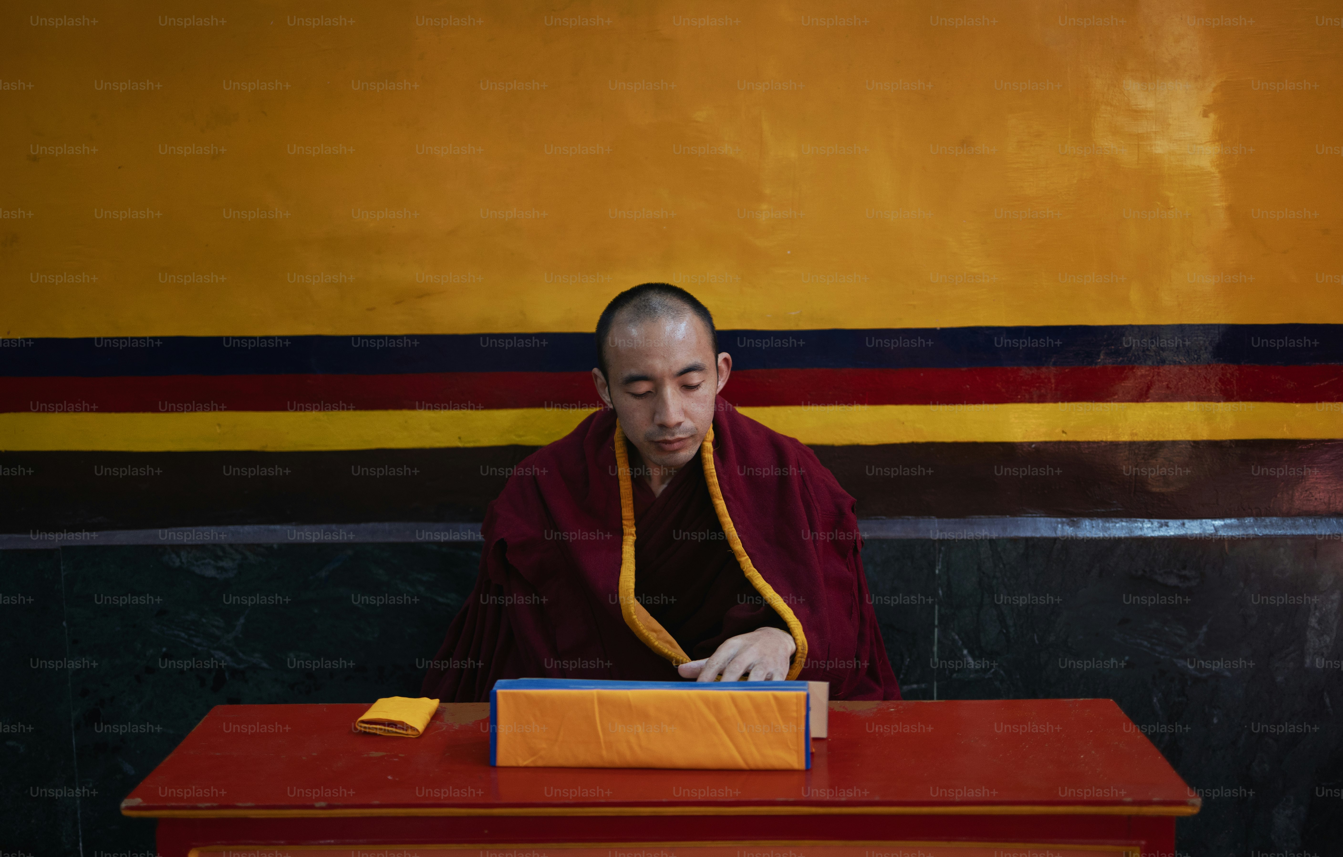 A man sitting at a desk in front of a painting