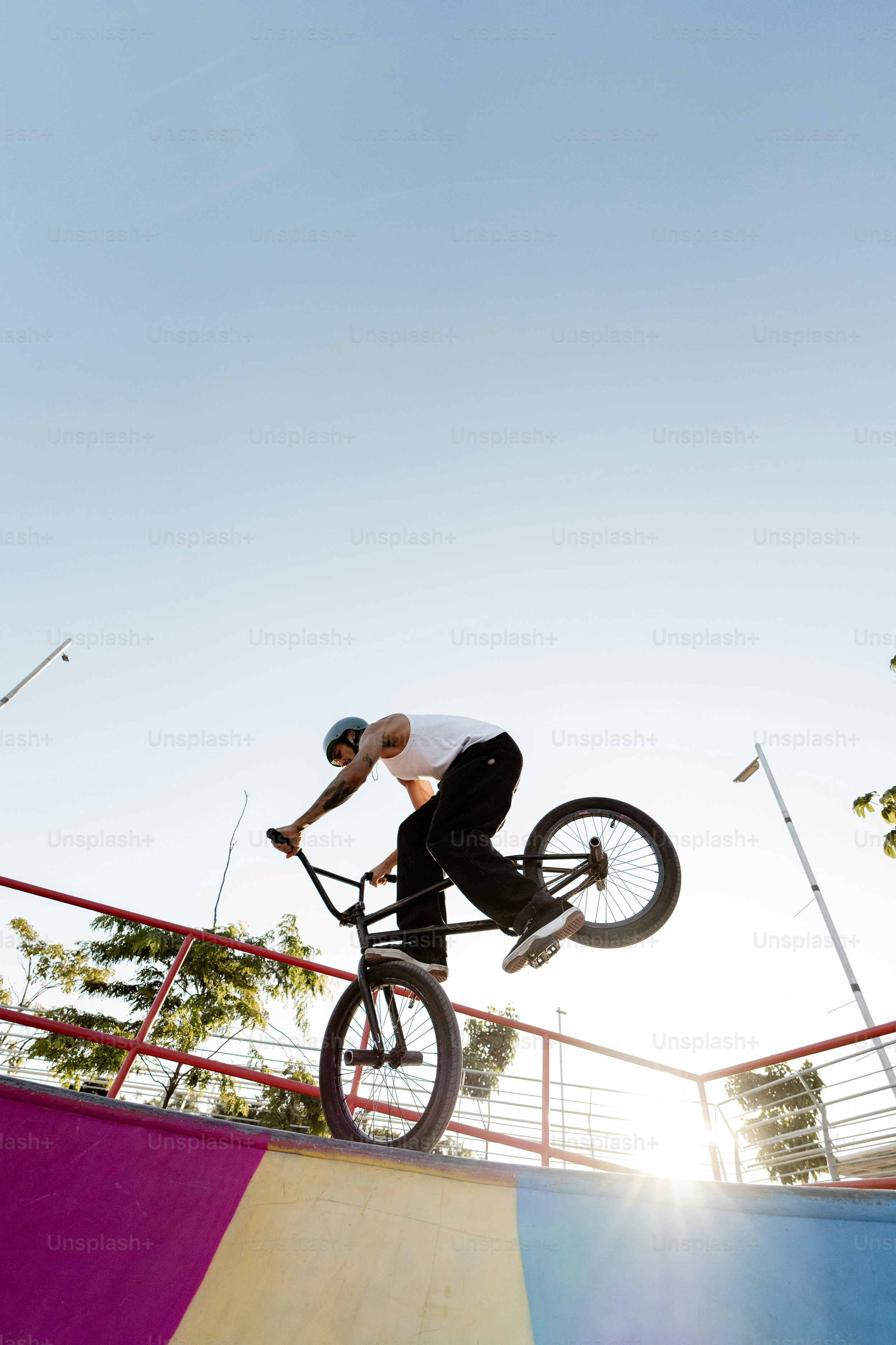 A man riding a bike up the side of a ramp photo – Bike trends Image on ...