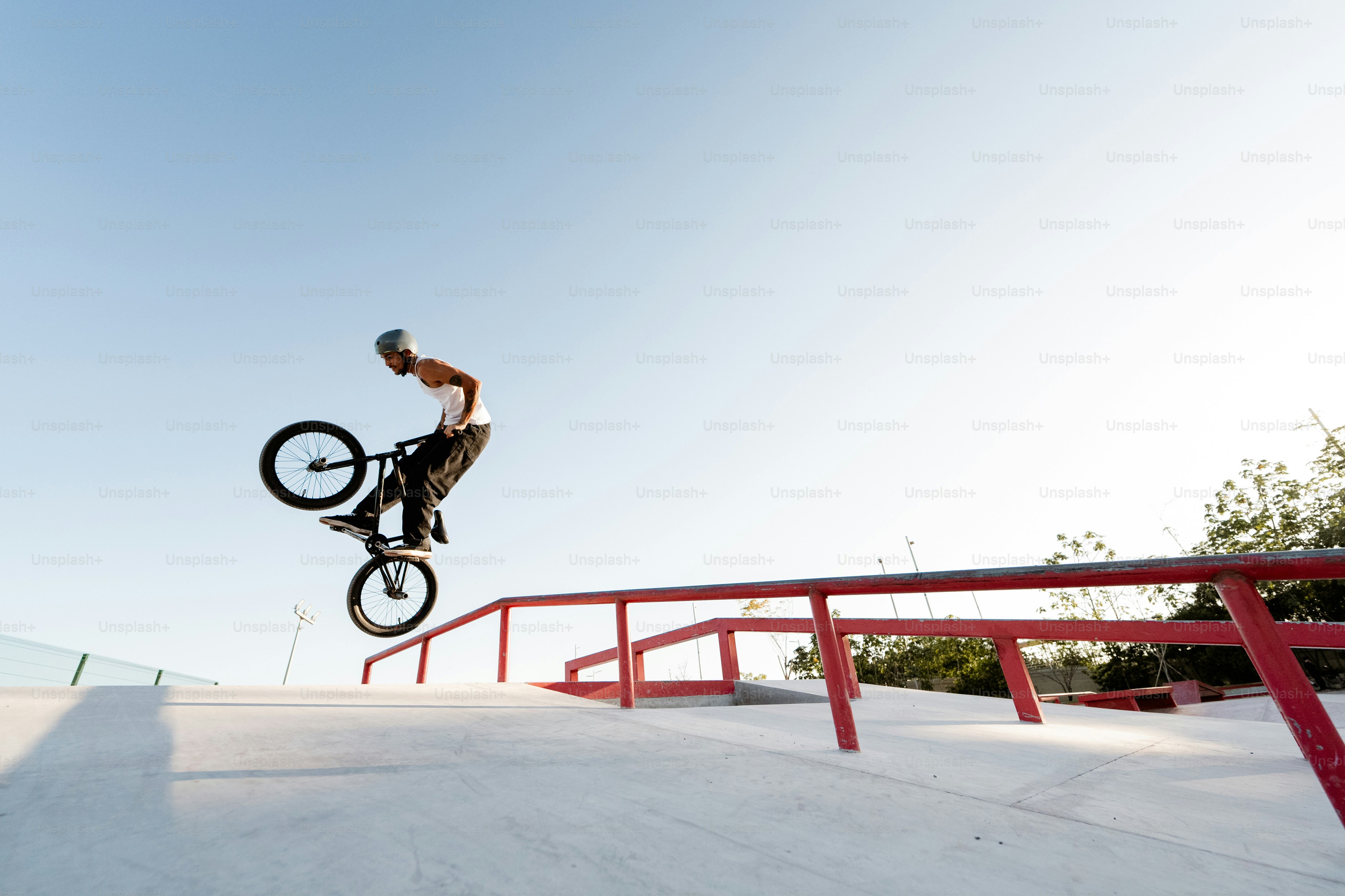 A man riding a bike up the side of a ramp photo – Bike trends Image on ...