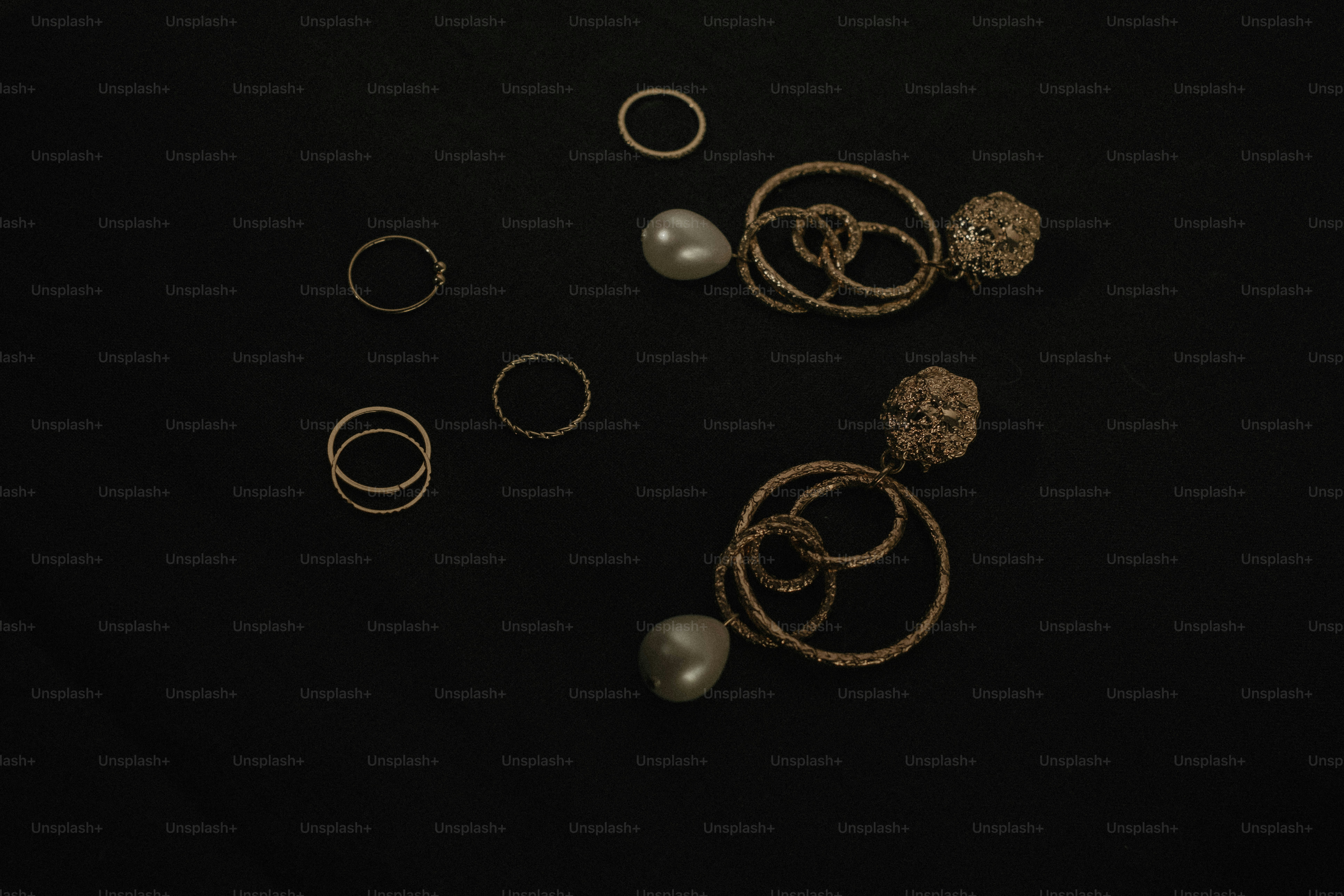 A group of rings and pearls on a black surface