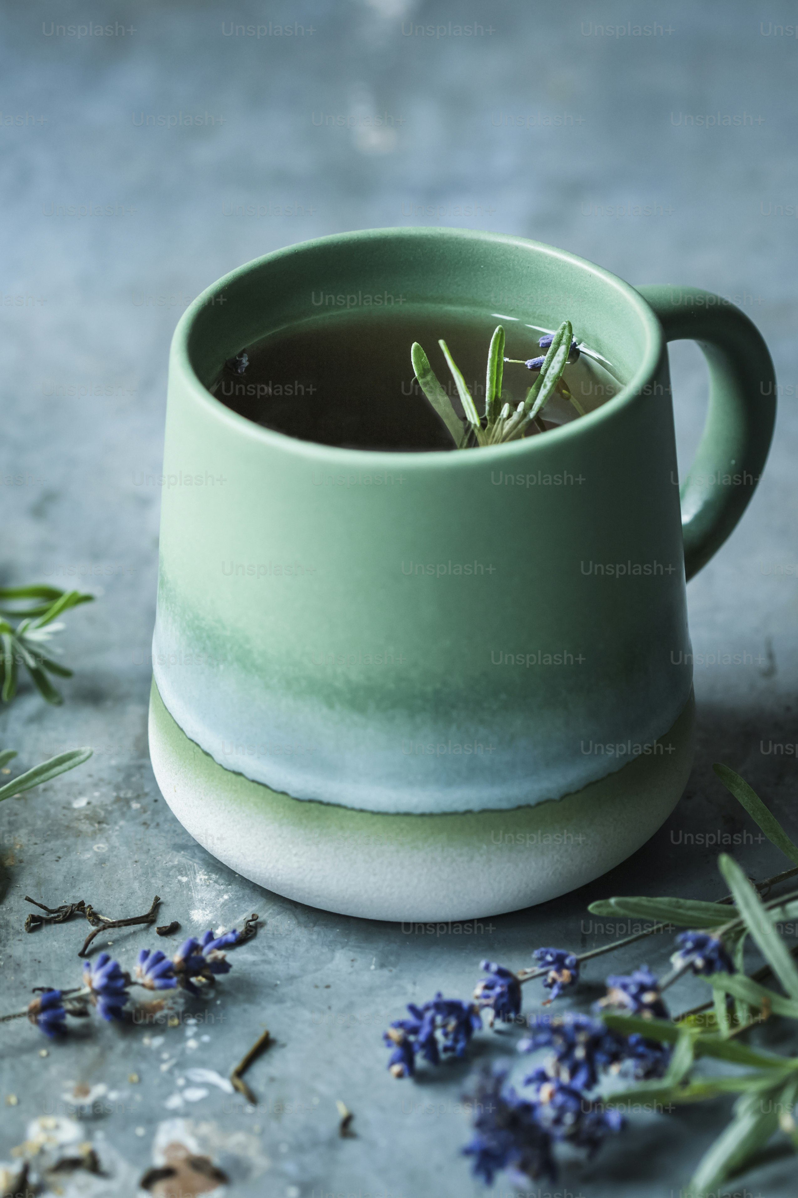 Une tasse de thé avec un brin de romarin dedans