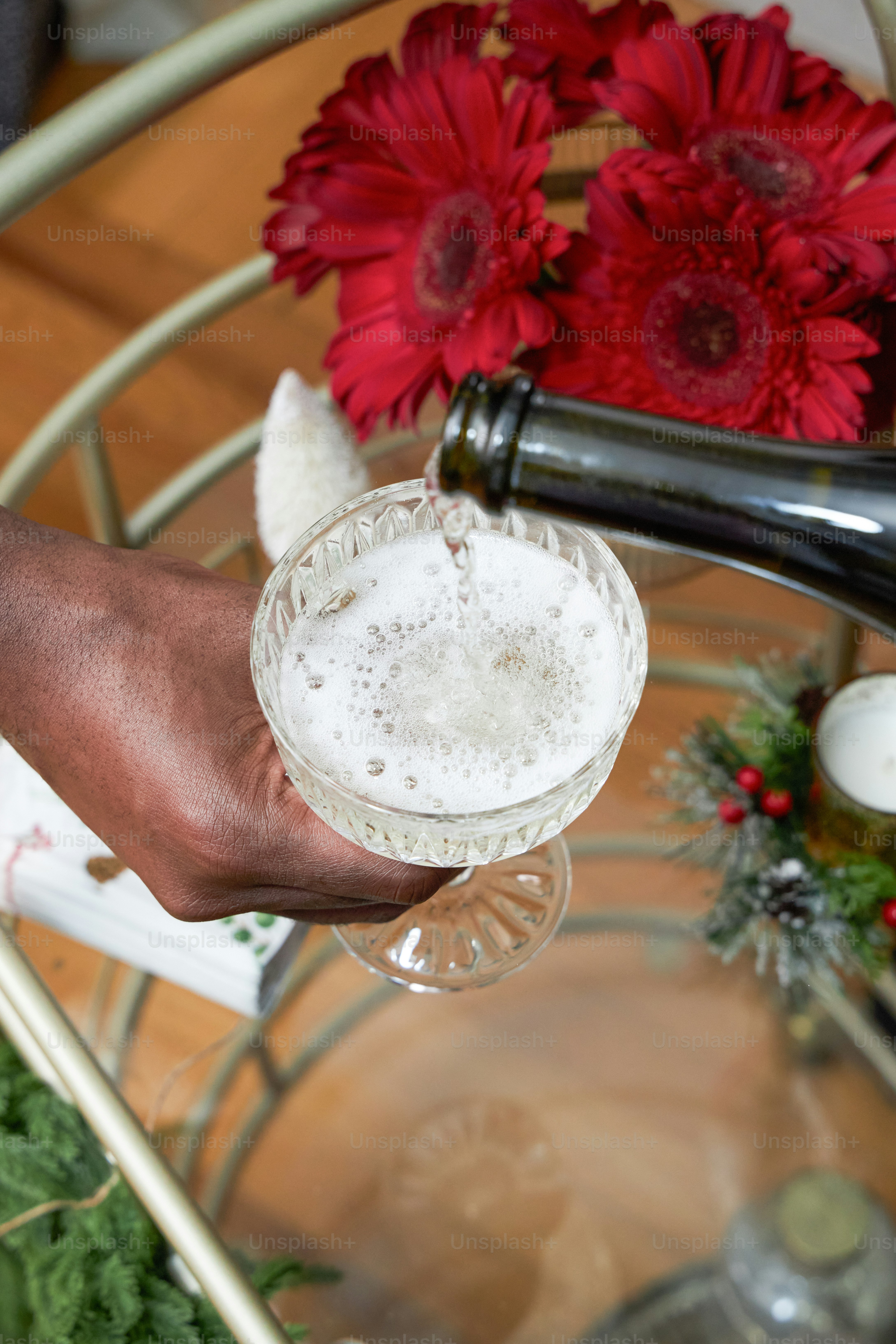 A person pouring a glass of beer on top of a table