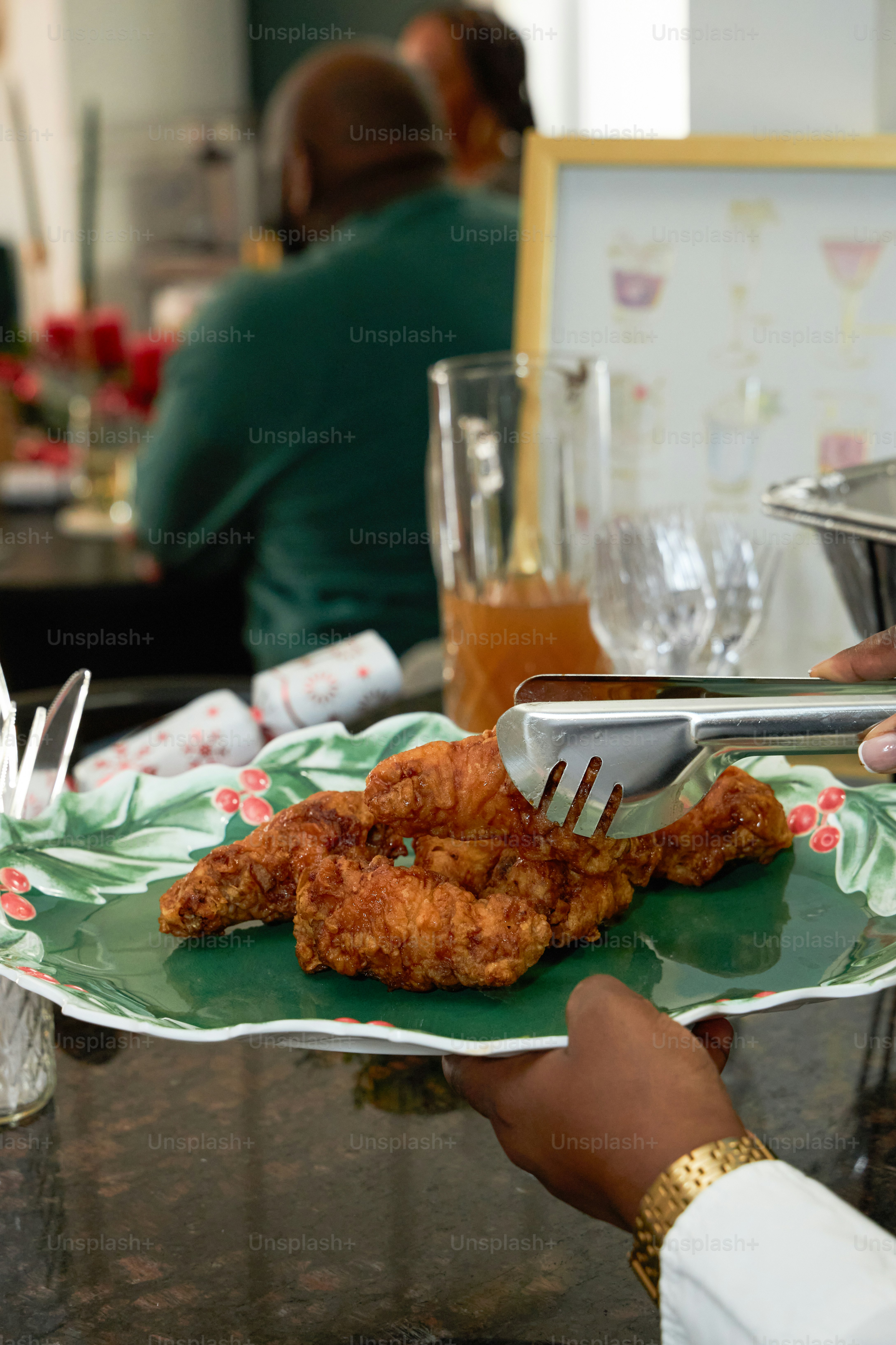 A person cutting a piece of fried chicken on a plate