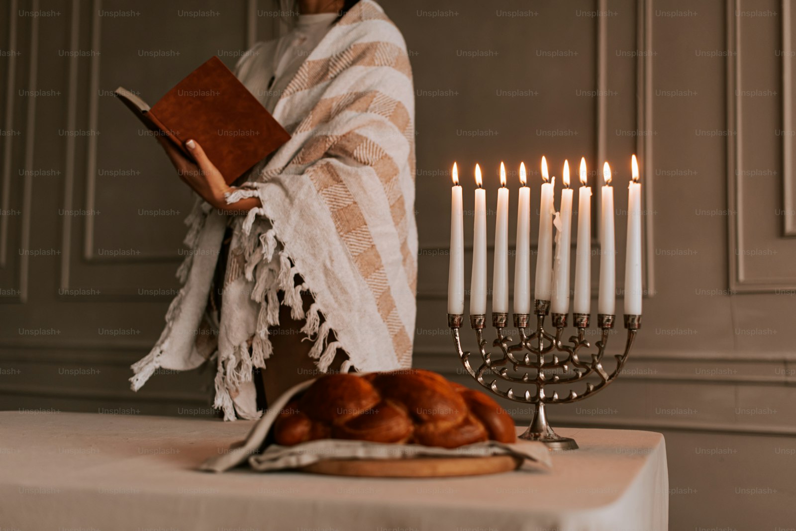 Shabbat table with tallit, menorah, and challah