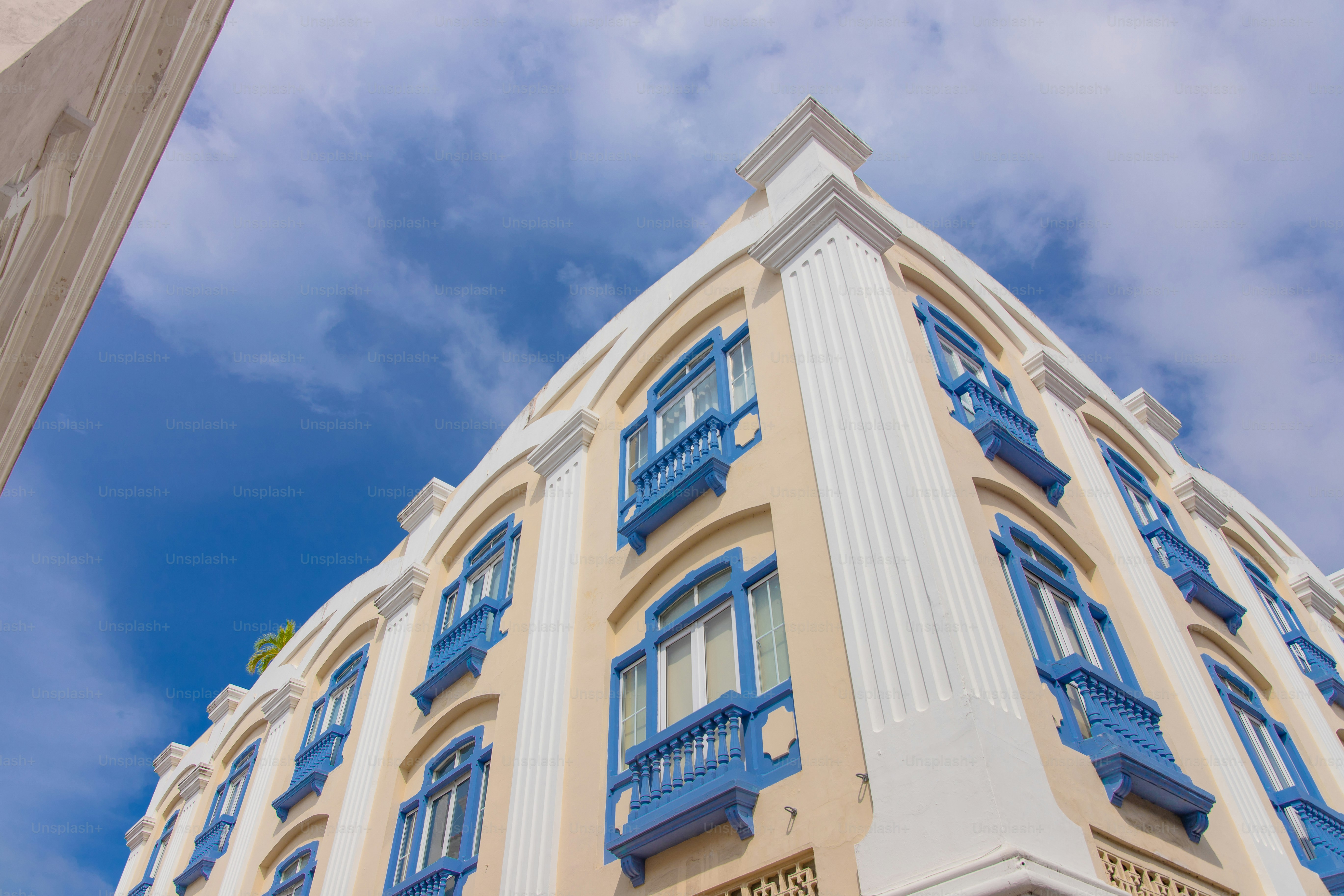 Un grand bâtiment avec des fenêtres et des balcons bleus